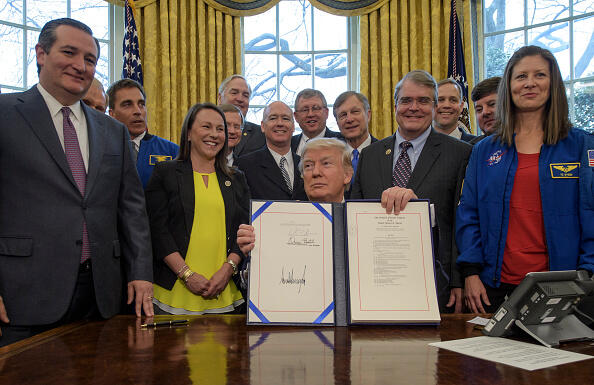 WASHINGTON, DC - MARCH 21:  In this handout provided by the National Aeronautics and Space Administration (NASA),   President Donald Trump, center, signs the NASA Transition Authorization Act of 2017, alongside members of the Senate, Congress, and National Aeronautics and Space Administration in the Oval Office of the White House in Washington, Tuesday, March 21, 2017. Also pictured, Sen. Ted Cruz, R-Texas, left, NASA Astronaut Office Chief Chris Cassidy, blue jacket left, Rep. John Culberson, R-Texas, right of President, NASA Astronaut Tracy Caldwell Dyson, and others.     (Photo by Bill Ingalls/NASA via Getty Images)