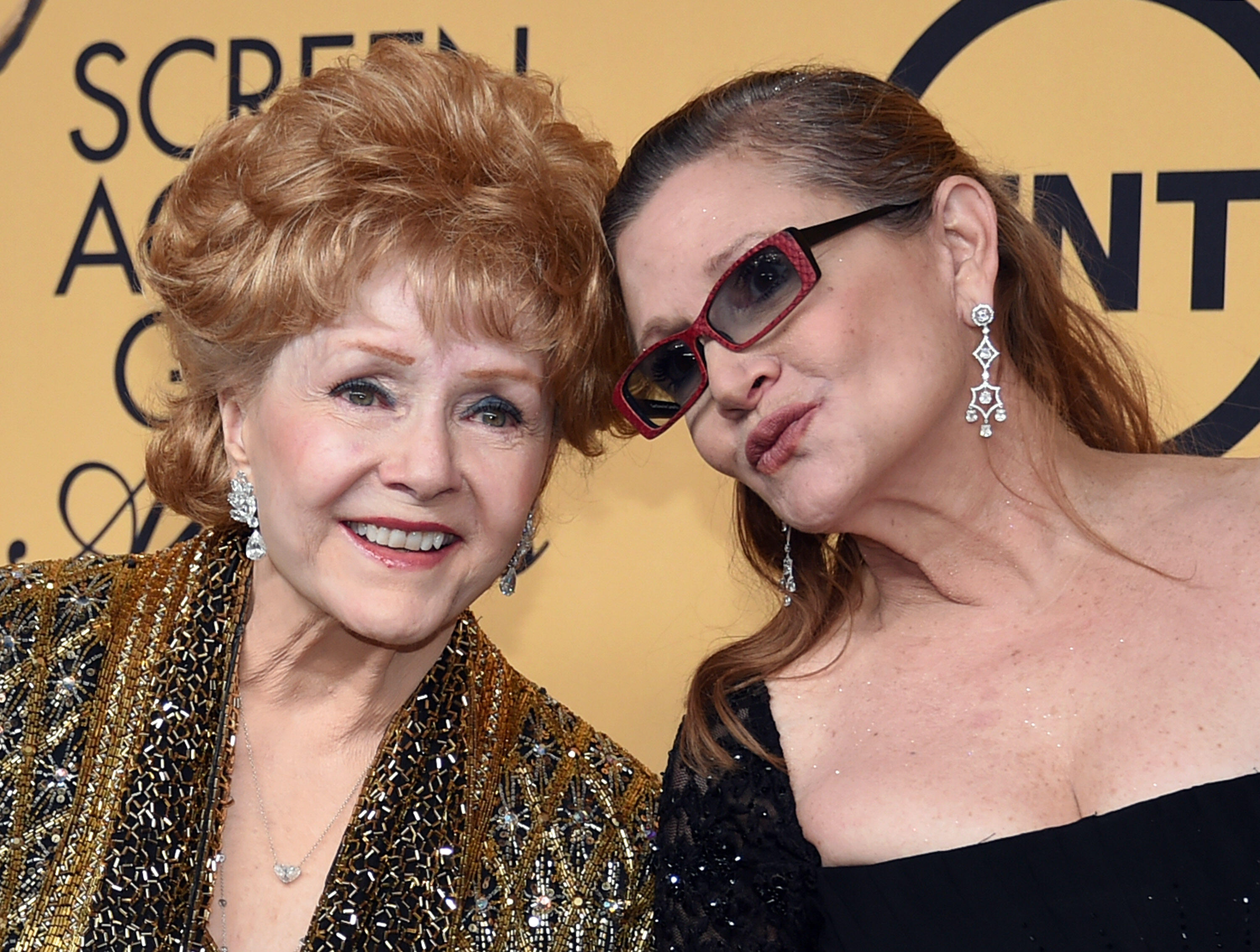 LOS ANGELES, CA - JANUARY 25:  Actress Debbie Reynolds (L), recipient of the Screen Actors Guild Life Achievement Award, and her daughter, actress Carrie Fisher, pose in the press room during the 21st Annual Screen Actors Guild Awards at The Shrine Audito