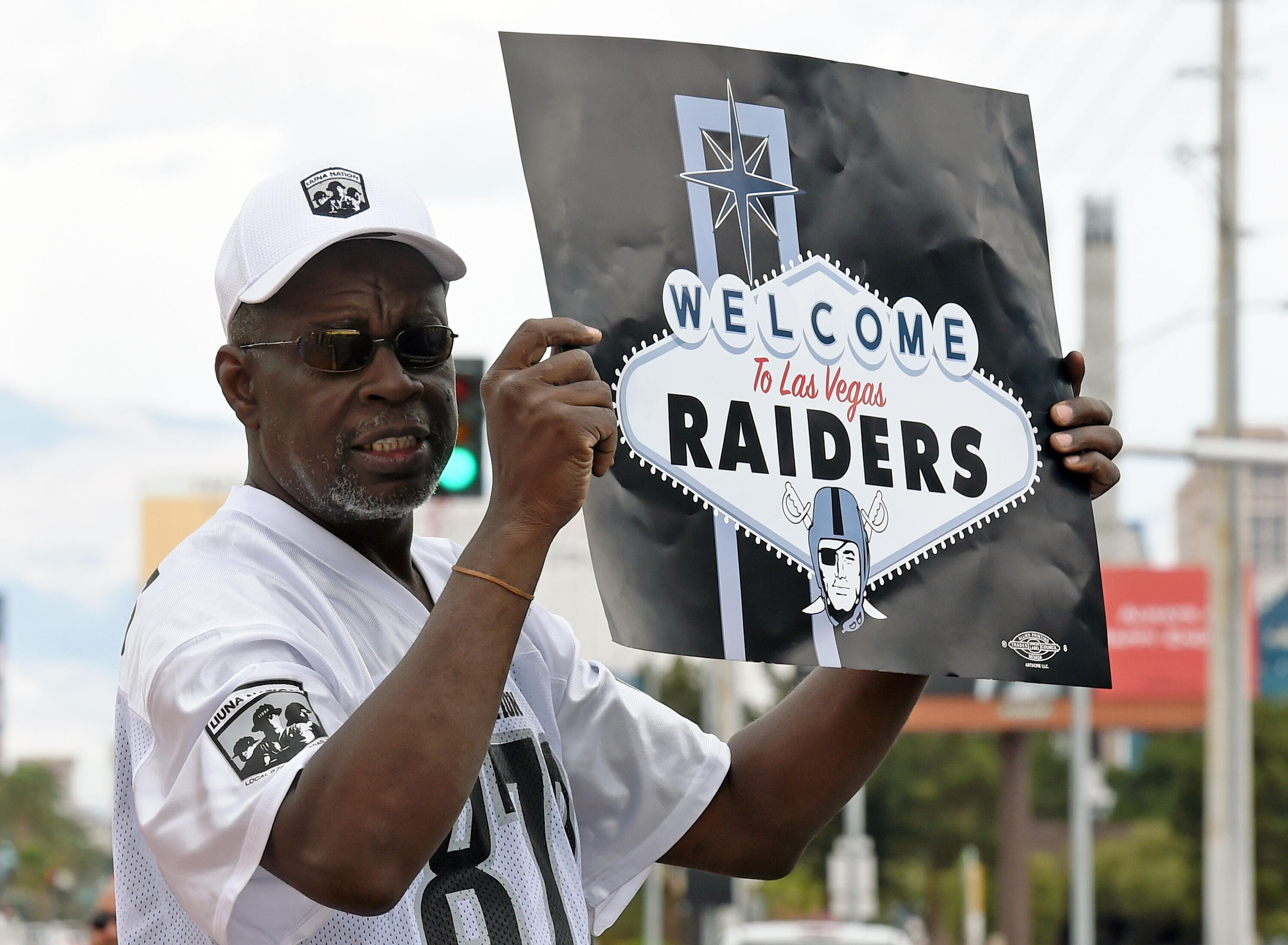 LAS VEGAS, NV - MARCH 27:  Oakland Raiders fan Davi Tole of Nevada displays a sign to passing motorists on the Las Vegas Strip near the Welcome to Fabulous Las Vegas sign after National Football League owners voted 31-1 to approve the team's application t