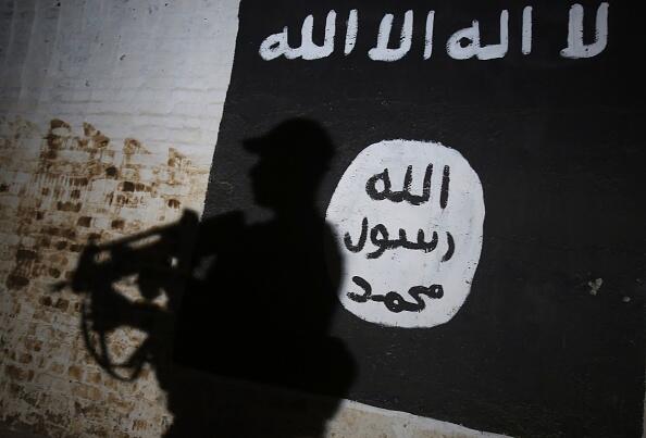 A member of the Iraqi forces walks past a mural bearing the logo of the Islamic State (IS) group in a tunnel that was used as a training centre by the jihadists, on March 1, 2017, in the village of Albu Sayf, on the southern outskirts of Mosul. Iraqi forces launched a major push on February 19 to recapture the west of Mosul from the Islamic State jihadist group, retaking the airport and then advancing north. / AFP / AHMAD AL-RUBAYE        (Photo credit should read AHMAD AL-RUBAYE/AFP/Getty Images)