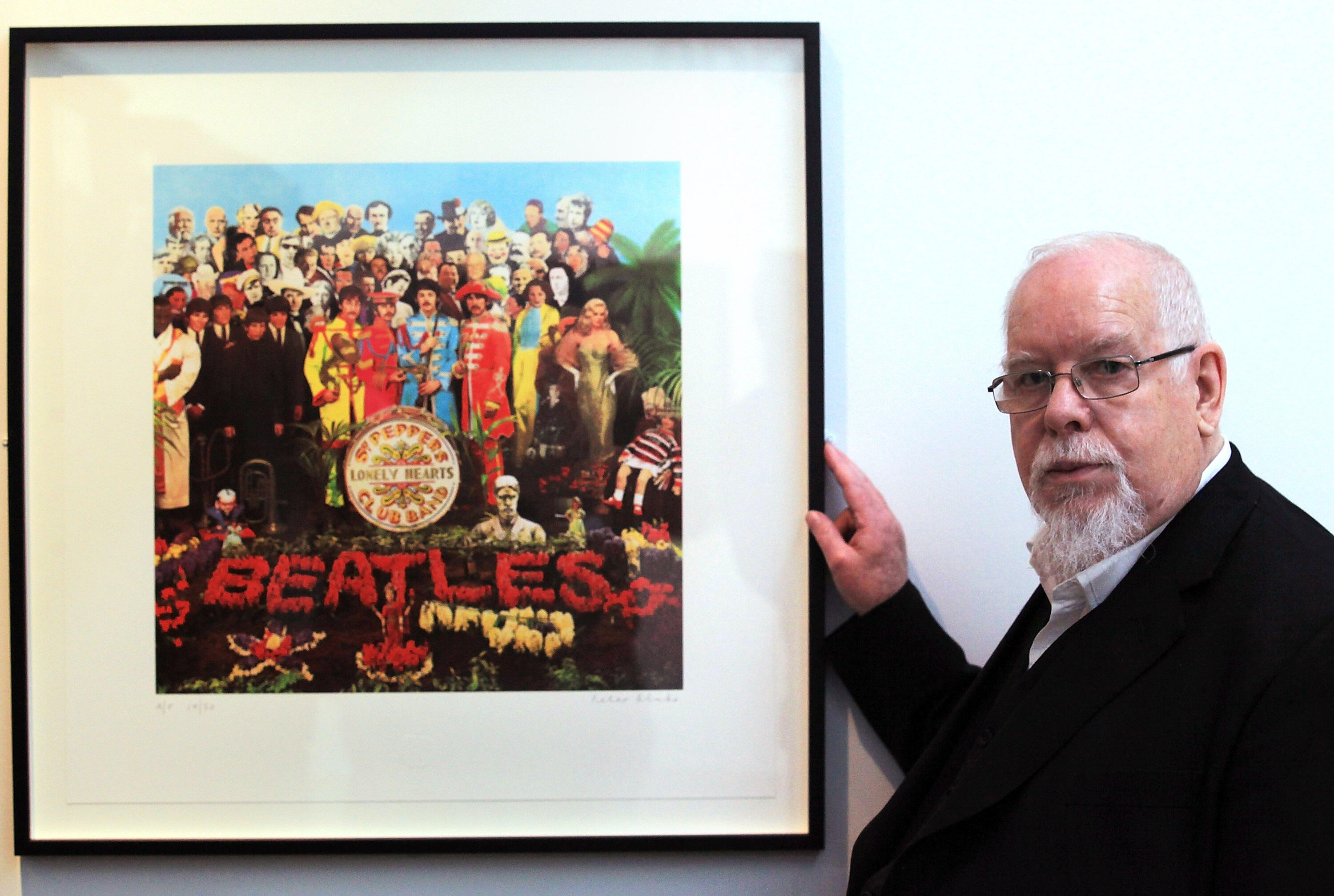 BATH, ENGLAND - MAY 12:  Artist Peter Blake poses for a photograph besides a copy of The Beatles Sgt Pepper LP album cover that he designed in 1967 as he reopens the Holburne Museum on May 12, 2011 in Bath, England. The new museum's first exhibition  - wh