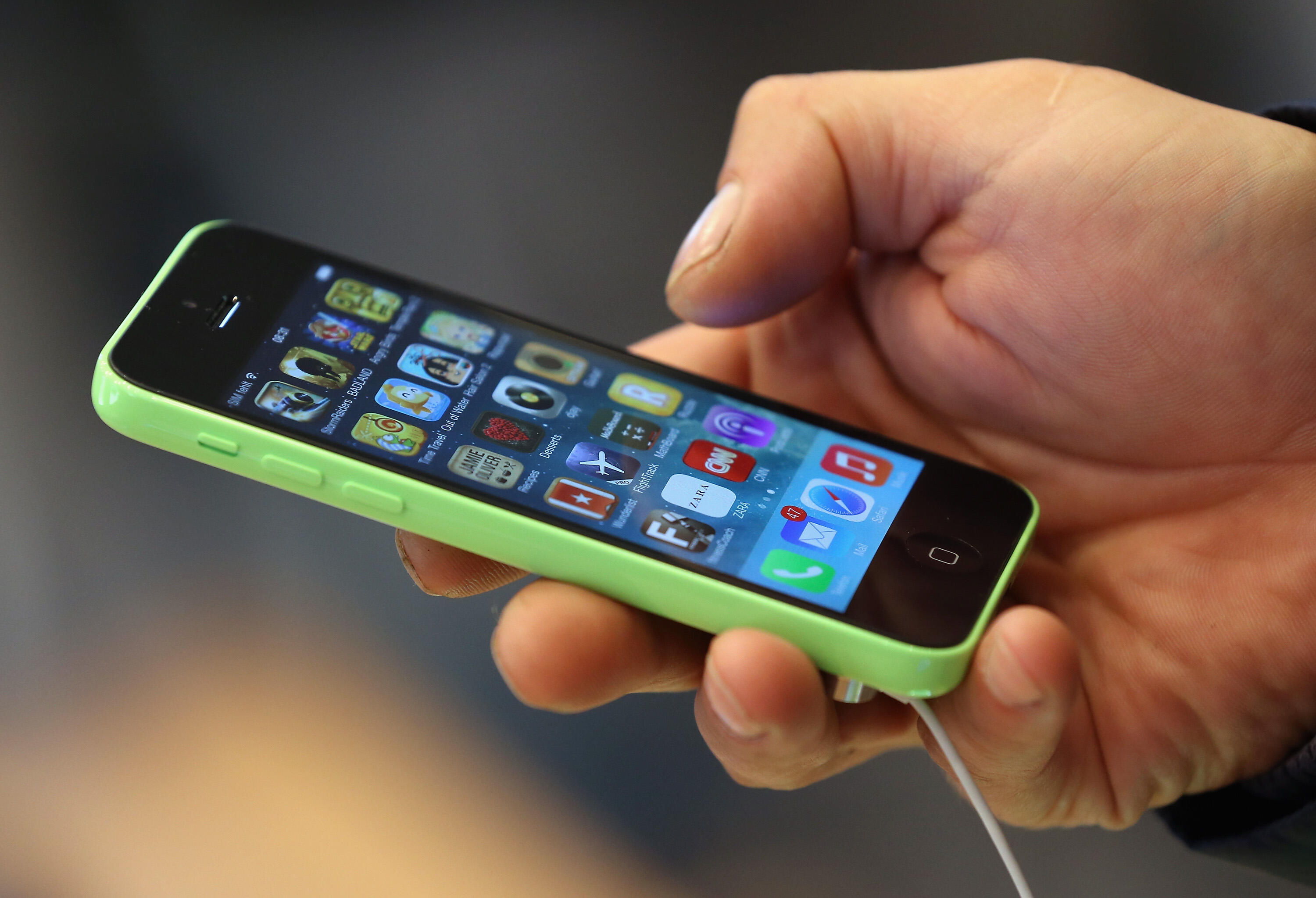 BERLIN, GERMANY - SEPTEMBER 20:  A customer tries out the new Apple iPhone 5C smartphone at the Berlin Apple Store on the first day of sales on September 20, 2013 in Berlin, Germany. The new iPhone 5S and 5C phones went on sale all over the world today an