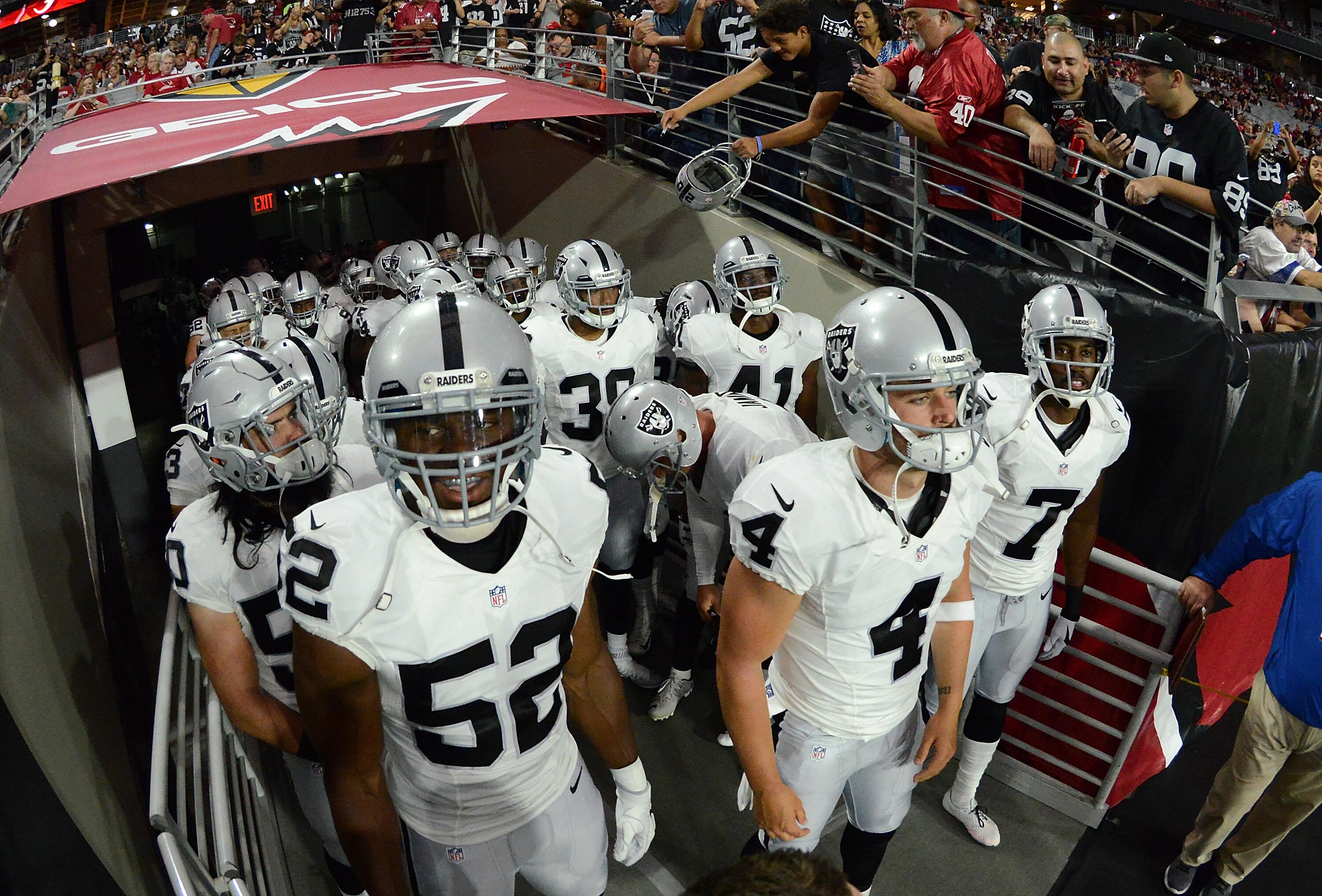 GLENDALE, AZ - AUGUST 12:  Derek Carr #4, Khalil Mack #52 and Marquette King #7 of the Oakland Raiders and teammates get ready to run onto the field prior to the start of a preseason game against the Arizona Cardinals at University of Phoenix Stadium on A