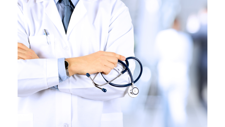 Portrait an unknown male doctor holding a stethoscope behind