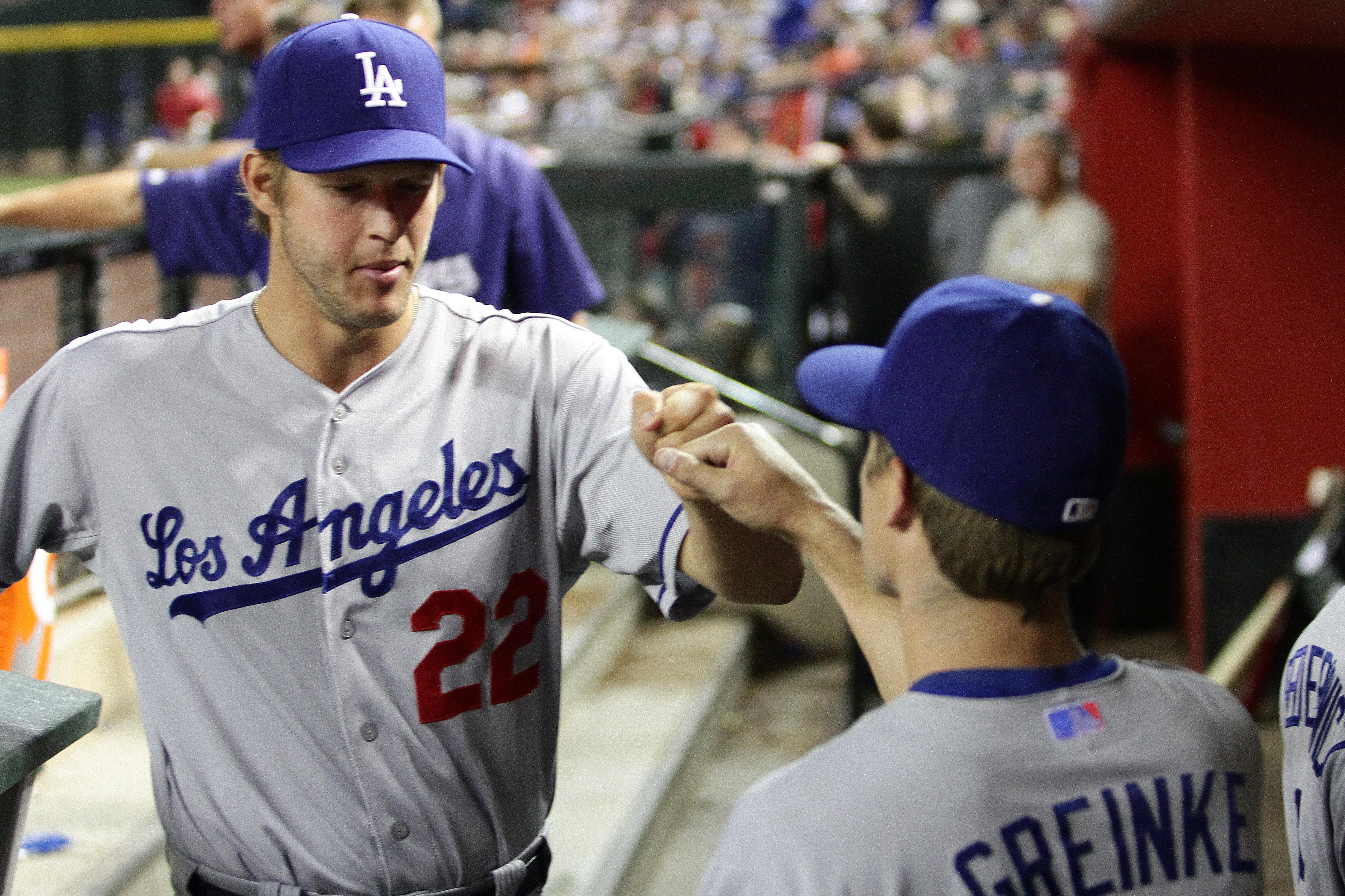 PHOENIX, AZ - APRIL 12:  Clayton Kershaw #22 and Zach Greinke #21 of the Los Angeles Dodgers fist bump in the sixth inning against the Arizona Diamondbacks at Chase Field on April 12, 2014 in Phoenix, Arizona.  (Photo by Jason Wise/Getty Images)