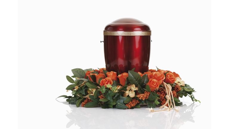 Cremation urn with wreath against white background