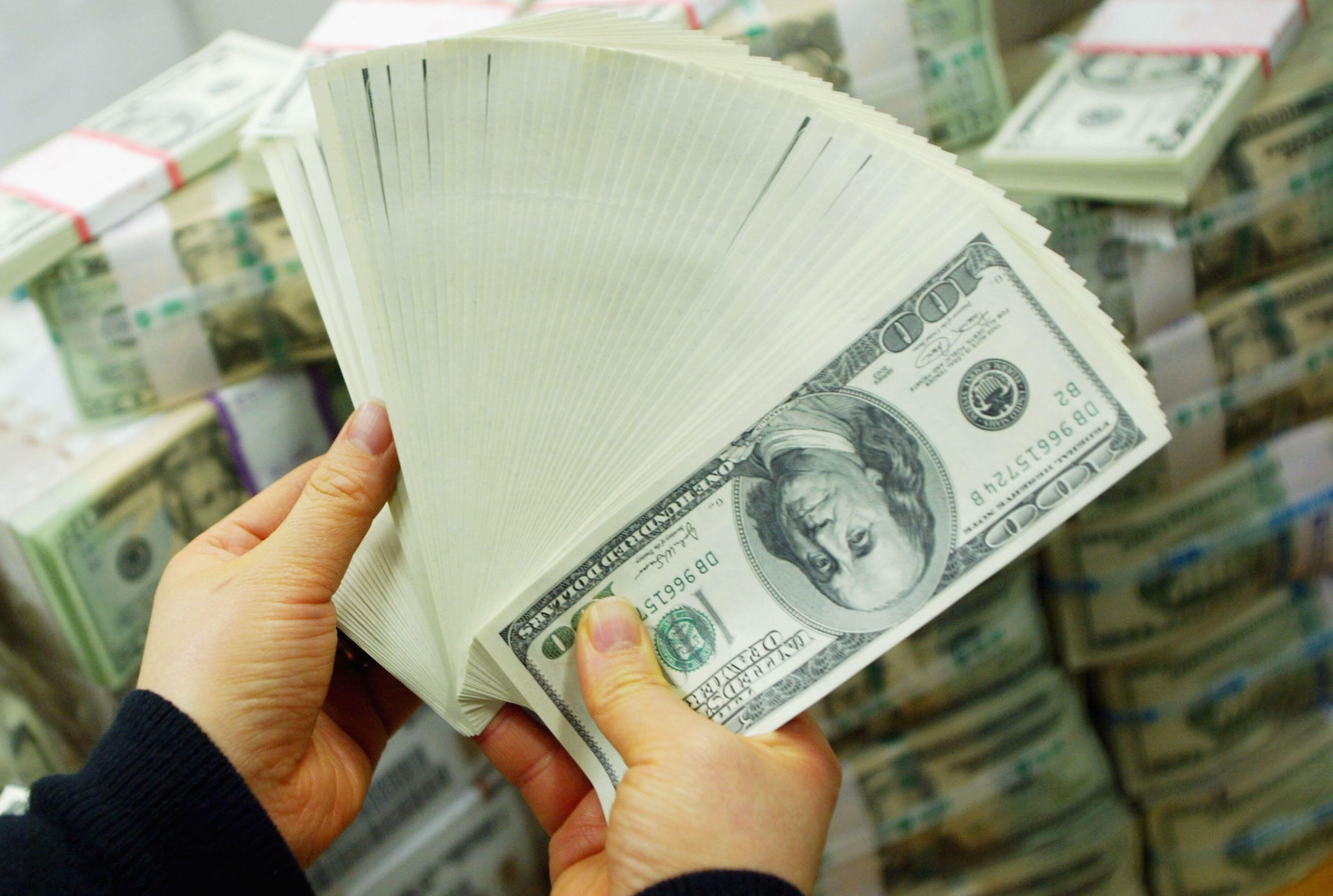 SEOUL, SOUTH KOREA - FEBRUARY 22:  A South Korean banker carries US dollar bank notes at the Korea Exchange bank on February 22, 2005 in Seoul, South Korea. The South Korean won jumped to its highest intraday level in more than seven years in domestic tra