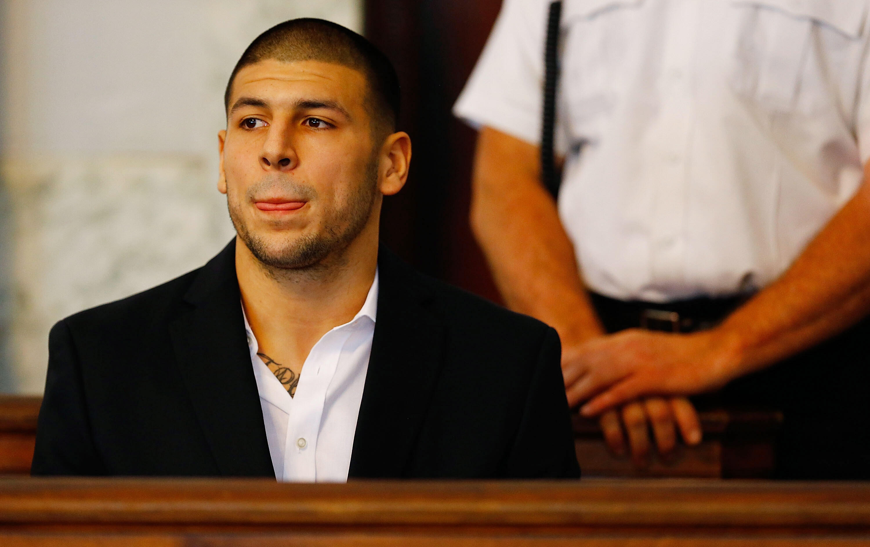 NORTH ATTLEBORO, MA - AUGUST 22: Aaron Hernandez sits in the courtroom of the Attleboro District Court during his hearing on August 22, 2013 in North Attleboro, Massachusetts. Former New England Patriot Aaron Hernandez has been indicted on a first-degree 