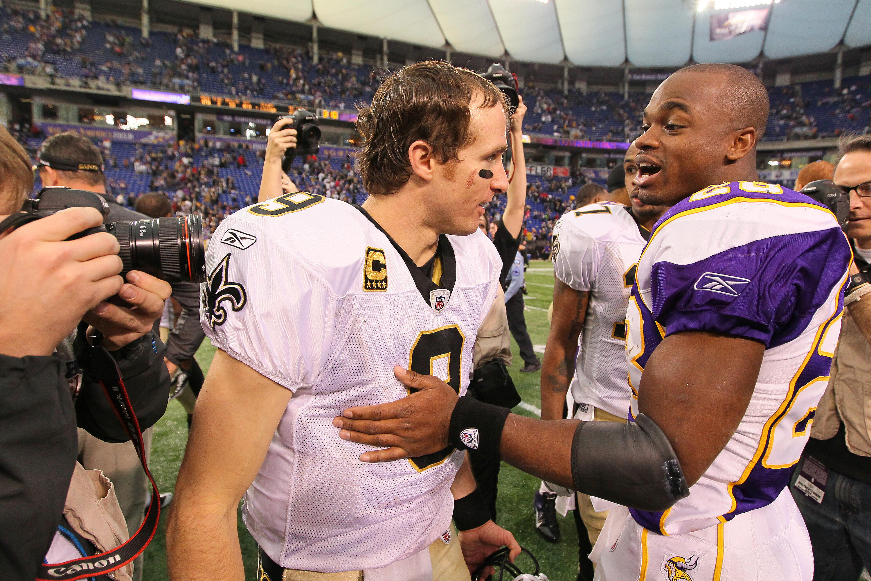 MINNEAPOLIS, MN - DECEMBER 18:   (L-R)  Drew Brees #9 of the New Orleans Saints and Adrian Peterson #28 of the Minnesota Vikings shake hands at the Hubert H. Humphrey Metrodome on December 18, 2011 in Minneapolis, Minnesota.  (Photo by Adam Bettcher /Gett