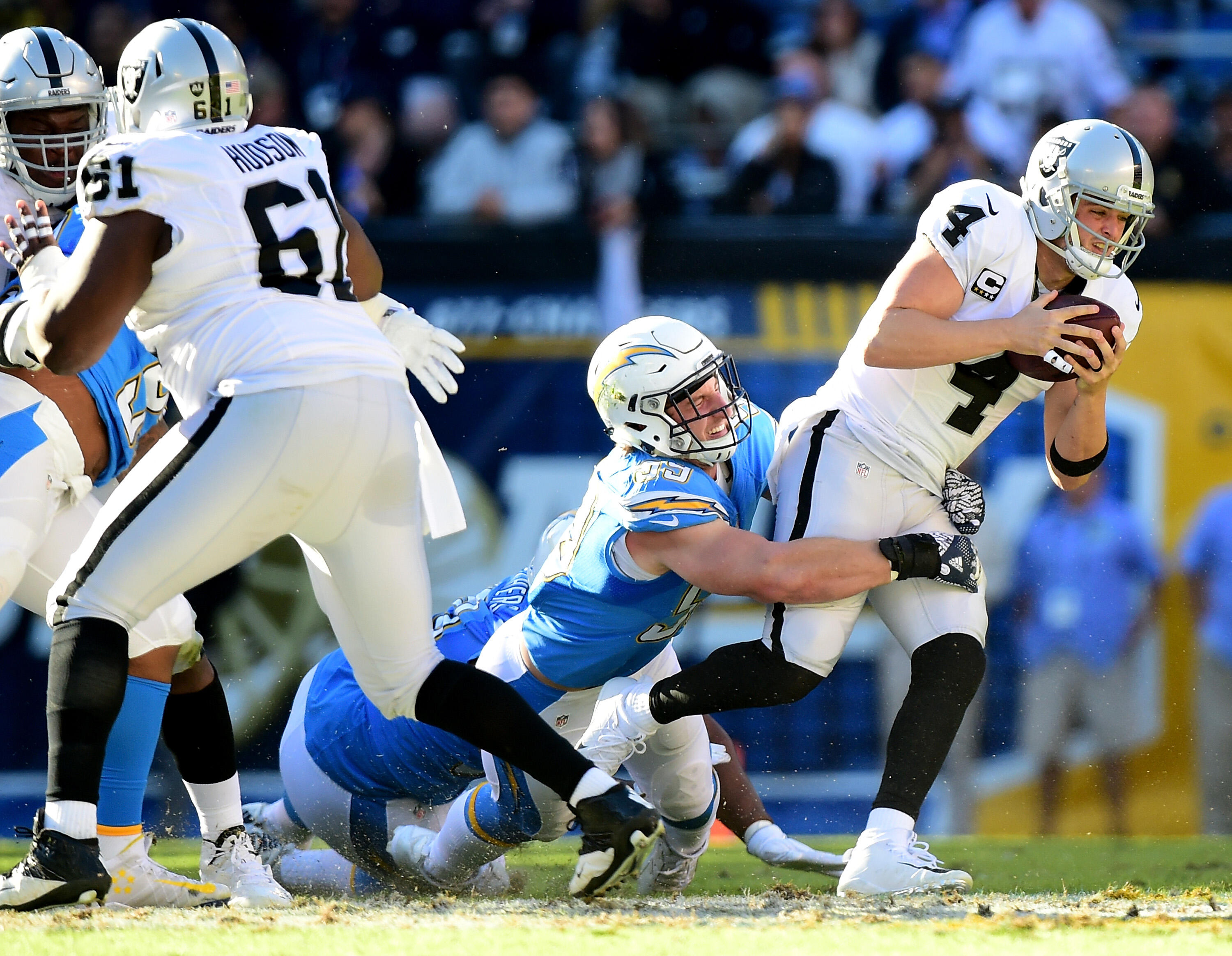 SAN DIEGO, CA - DECEMBER 18:  Derek Carr #4 of the Oakland Raiders is sacked for a six yard loss by Joey Bosa #99 of the San Diego Chargers during the second quarter at Qualcomm Stadium on December 18, 2016 in San Diego, California.  (Photo by Harry How/G