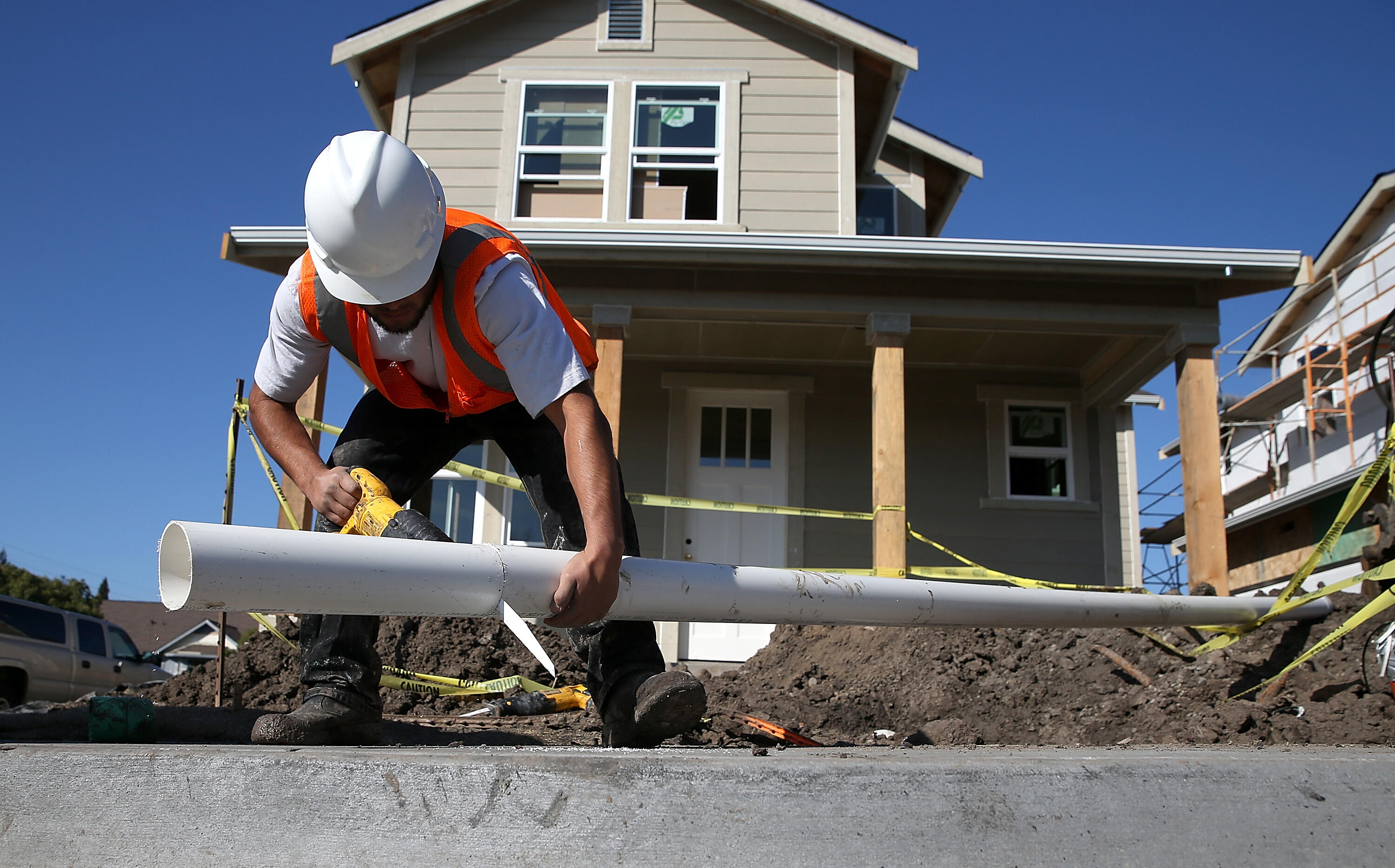 PETALUMA, CA - JANUARY 21:  A worker cuts a piece of pipe as he builds a new home on January 21, 2015 in Petaluma, California. According to a Commerce Department report, construction of new homes increased 4.4 percent in December, pushing building of new 