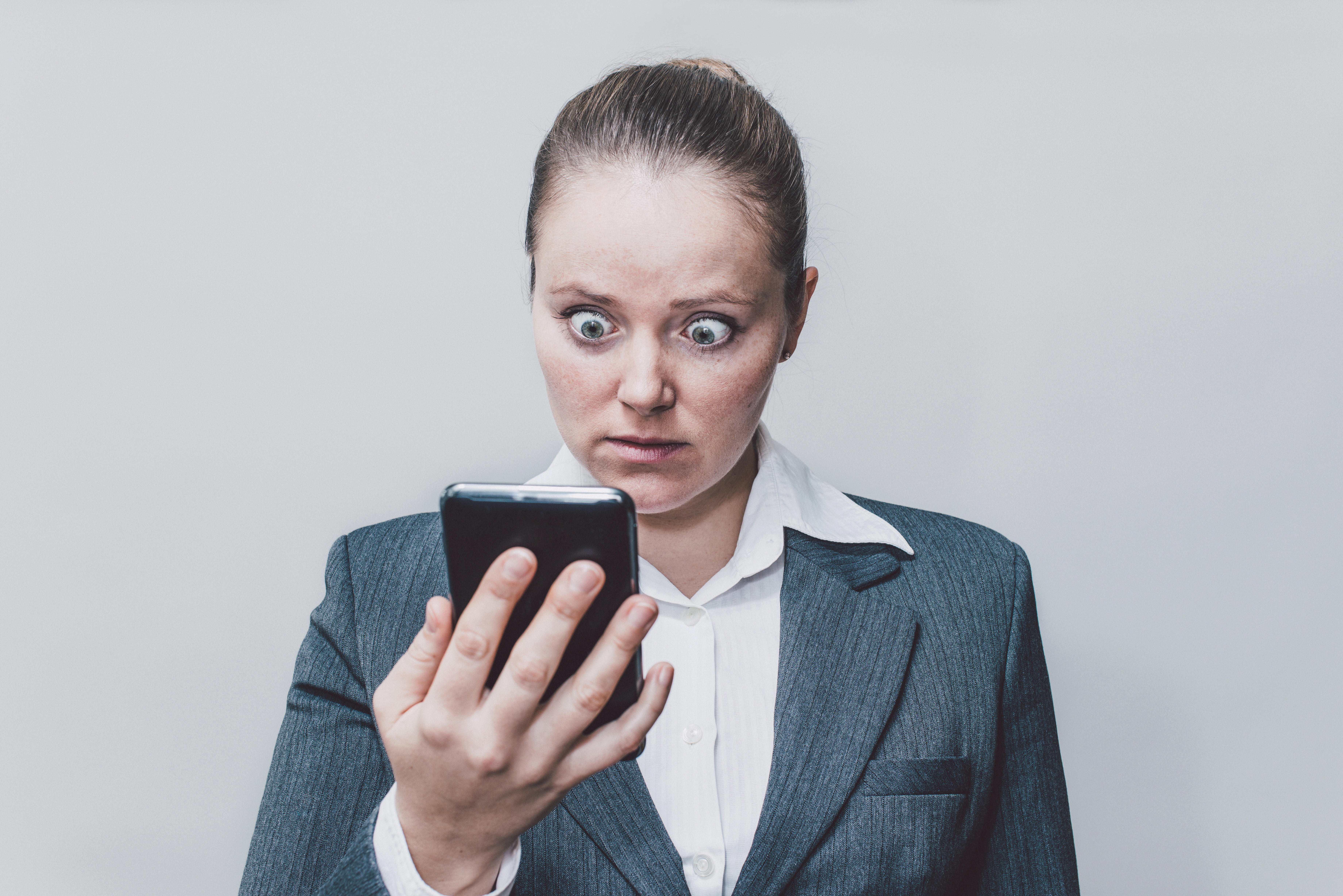 Businesswoman making big eyes while looking surprised.