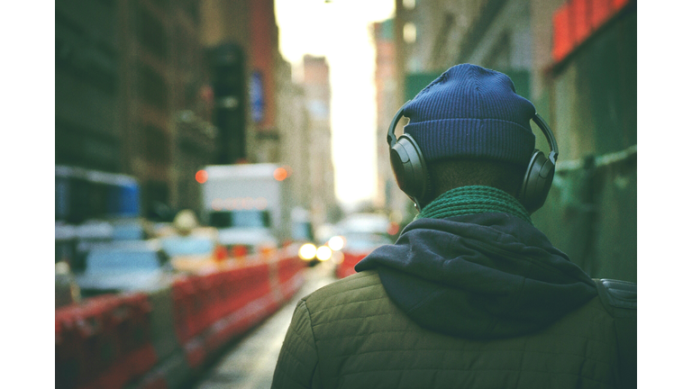 Rear View Of Man Listening To Music In Street