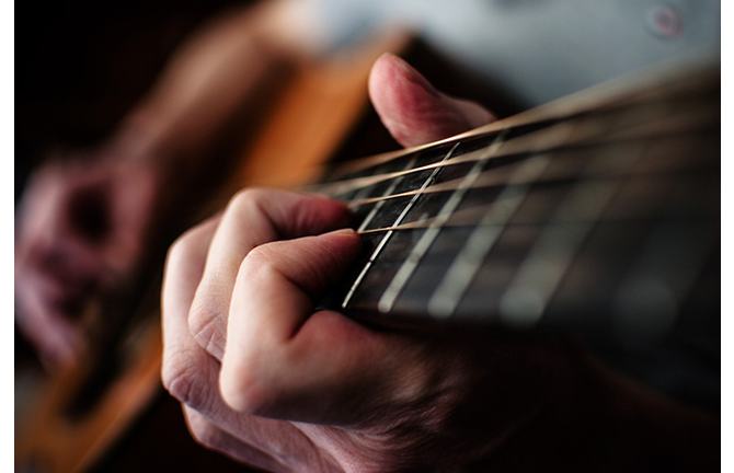 Close-Up Of Person Playing Guitar