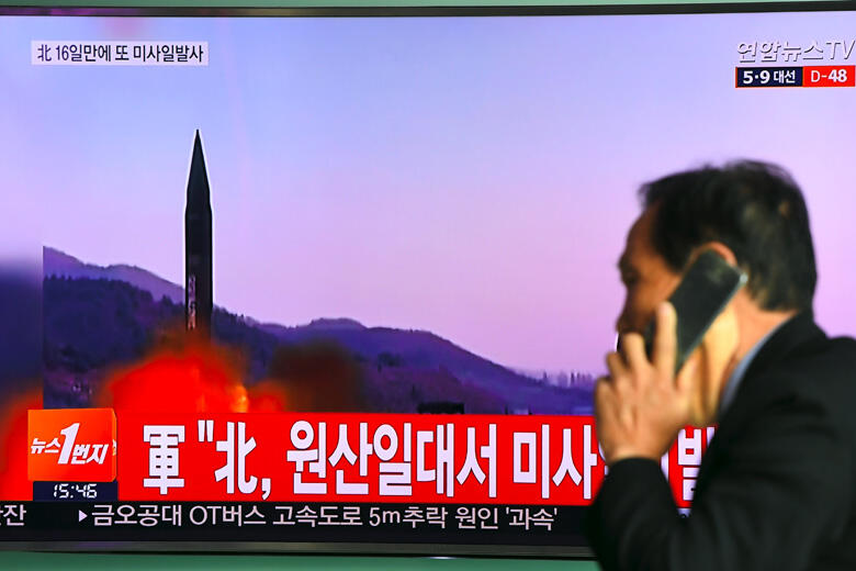 TOPSHOT - A man walks past a television screen showing file footage of a North Korean missile launch, at a railway station in Seoul on March 22, 2017. A new North Korean missile test failed on March 22, the South and US said, two weeks after Pyongyang lau