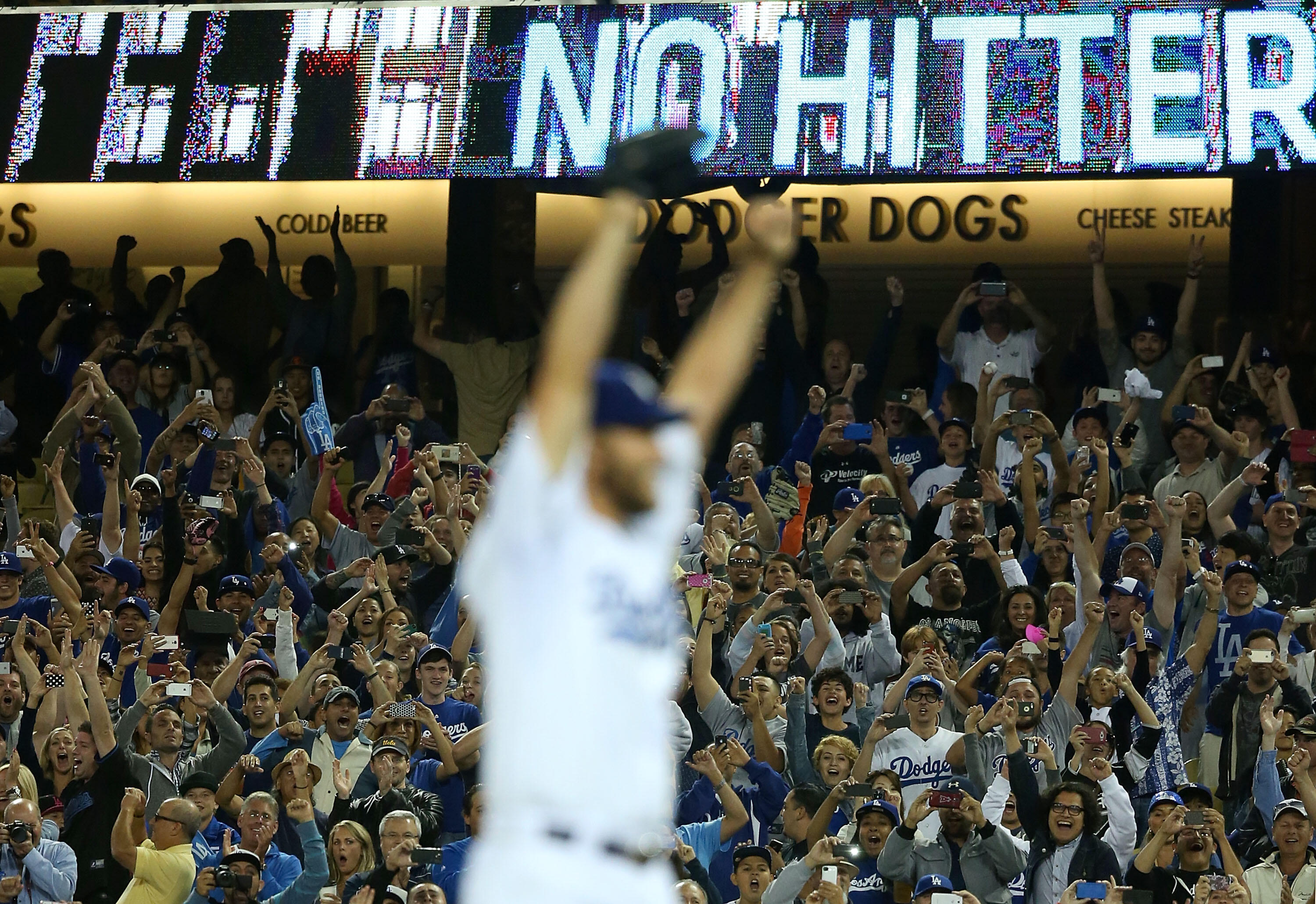 LOS ANGELES, CA - JUNE 18:  Pitcher Clayton Kershaw #22 of the Los Angeles Dodgers reacts (foreground) after pitching a no-hitter against the Colorado Rockies as fans jubilate in the background after the MLB game at Dodger Stadium on June 18, 2014 in Los 