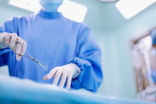 Hands of operating room staff performing surgery