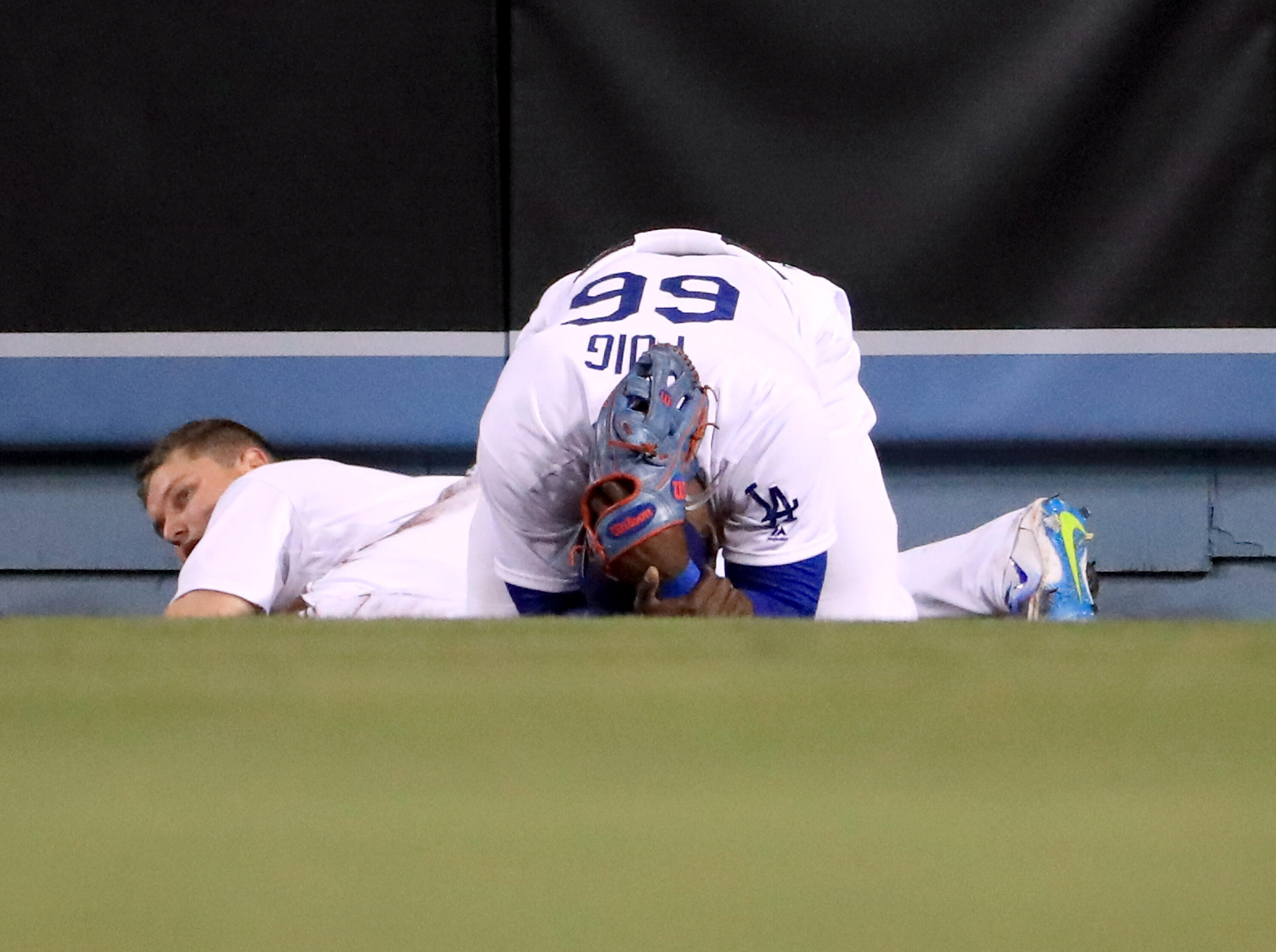 LOS ANGELES, CA - MAY 23:  Yasiel Puig #66 of the Los Angeles Dodgers reacts after colliding with Joc Pederson #31 after his catch for an out of Yadier Molina #4 of the St. Louis Cardinals to end the tenth inning at Dodger Stadium on May 23, 2017 in Los A