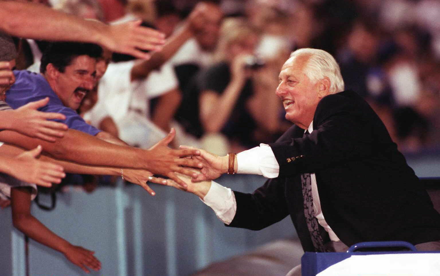 LOS ANGELES, UNITED STATES:  Former Los Angeles Dodger head coach Tommy Lasorda slaps fans hands as he rides around the field 07 September at Dodger Stadium.  Lasorda was honored by past and present players, coaches, writers and community members in a cer