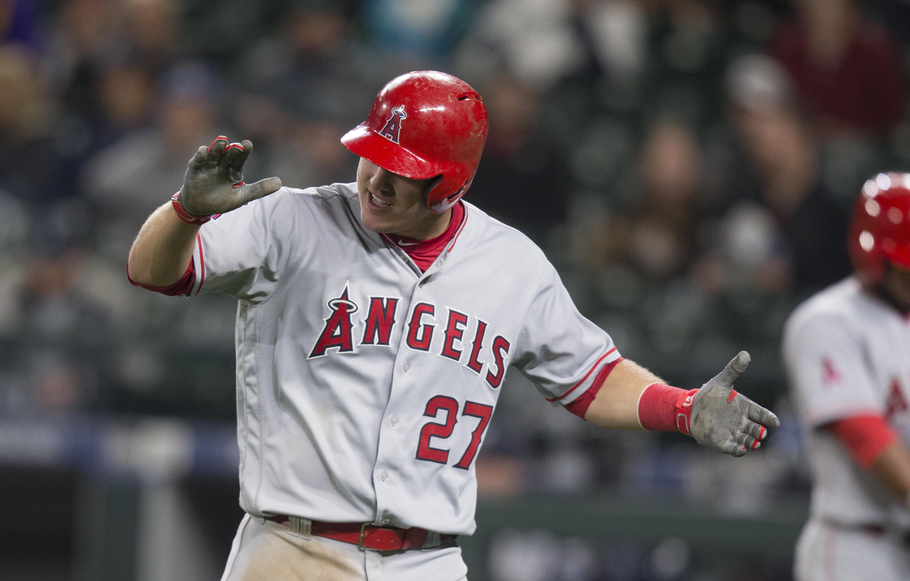 SEATTLE, WA - MAY 2: Mike Trout #27 of the Los Angeles Angels of Anaheim celebrates scoring a run on a double by Albert Pujols #5 of the Los Angeles Angels of Anaheim off of relief pitcher James Pazos #47 of the Seattle Mariners during the eleventh inning