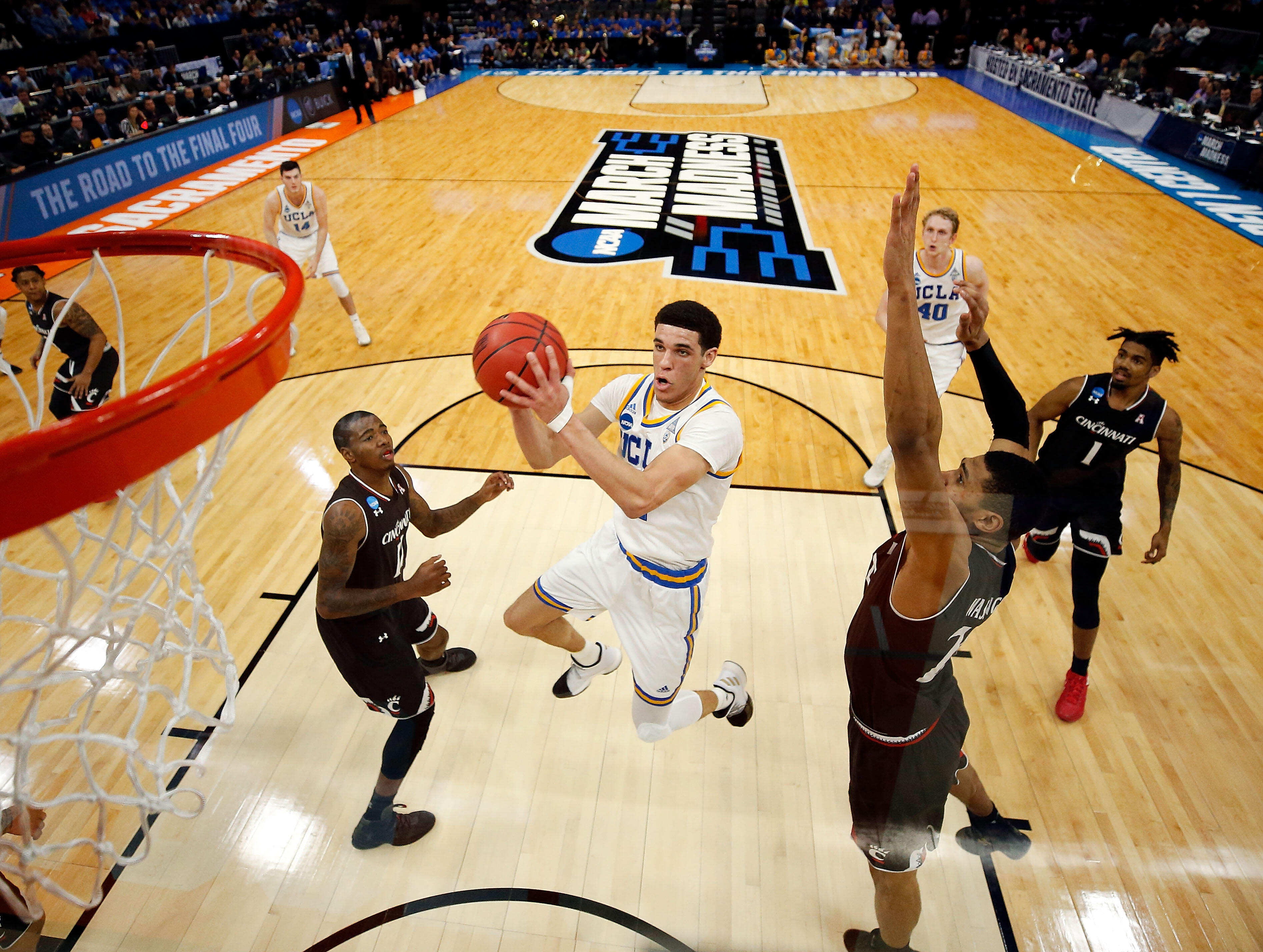 SACRAMENTO, CA - MARCH 19: Lonzo Ball #2 of the UCLA Bruins drives to the basket as Kyle Washington #24 of the Cincinnati Bearcats defends during the second round of the NCAA Basketball Tournament at Golden 1 Center on March 19, 2017 in Sacramento, Califo