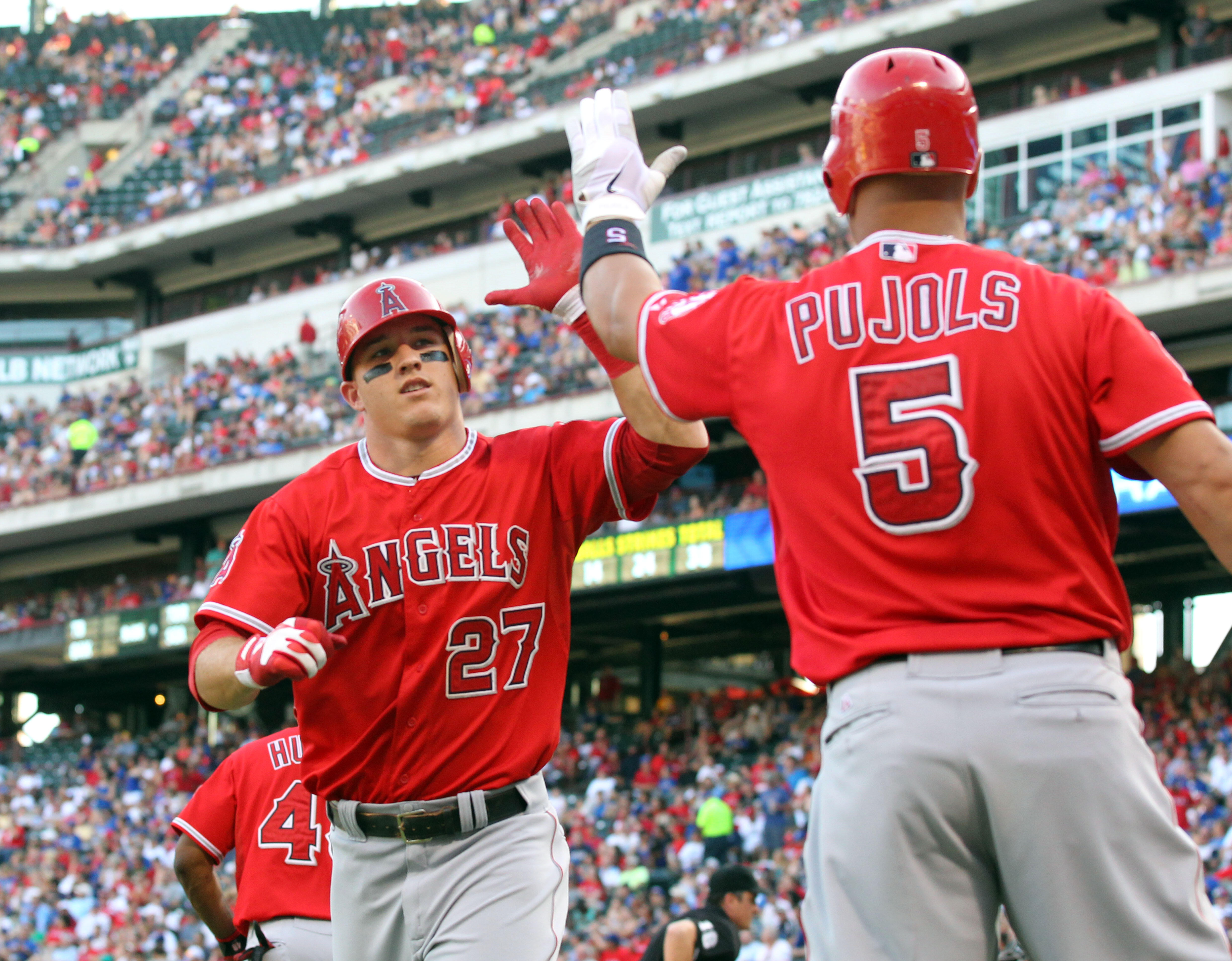 ARLINGTON, TX - JULY 30: Mike Trout #27 of the Los Angeles Angels of Anaheim Texas is congratulated by teammate Albert Pujols #5 at the plate after hitting a 2-run homer in the 3rd inning against the Rangers on July 30, 2012 at the Rangers Ballpark in Arl
