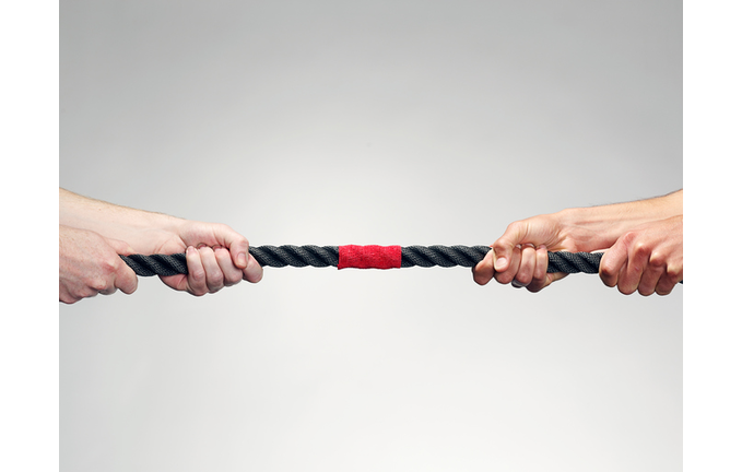 Hands pulling on rope during game of tug-of-war