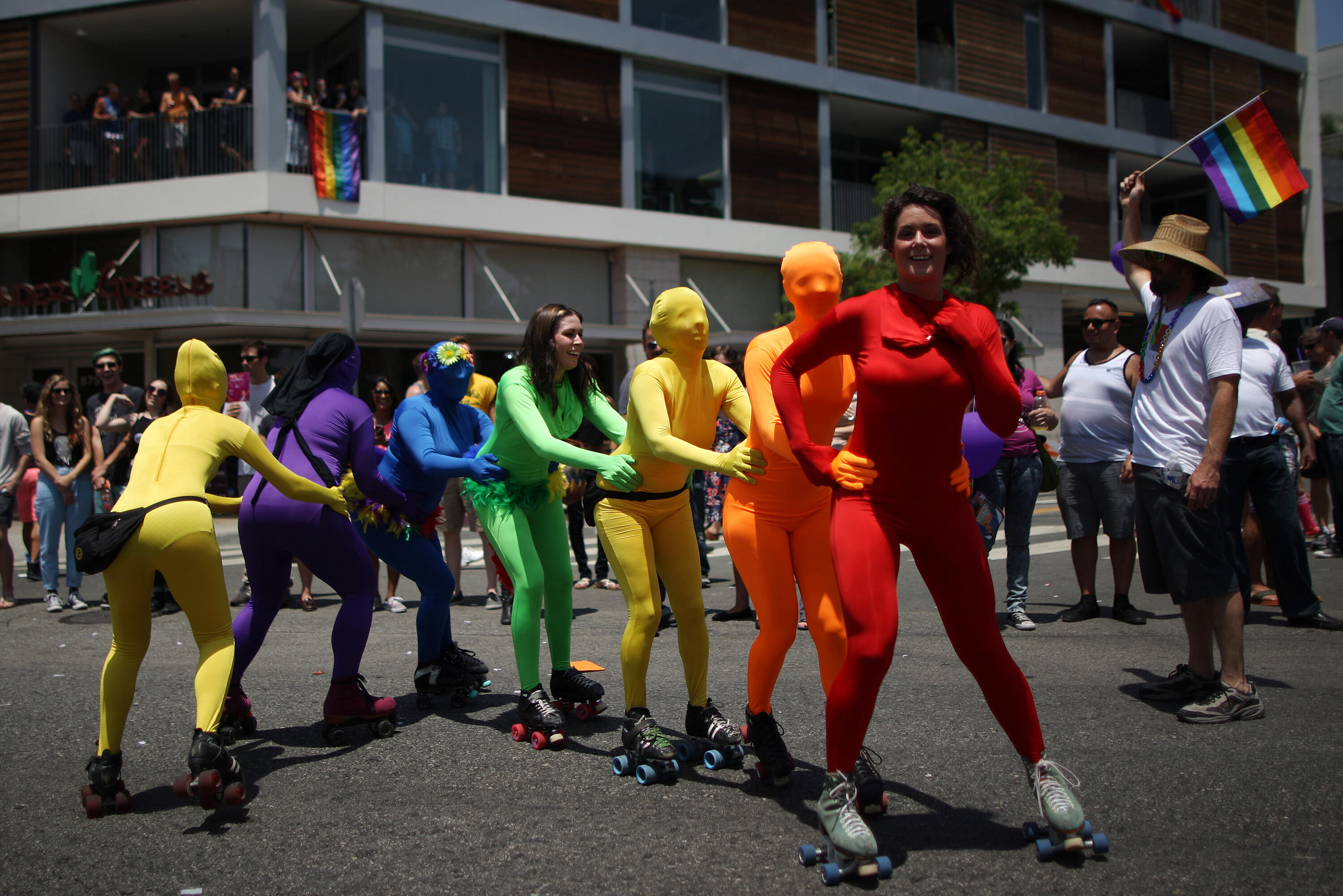WEST HOLLYWOOD, CA - JUNE 8:  Women roller skate in rainbow-colored body suits in the LA Pride Parade on June 8, 2014 in West Hollywood, California. The LA Pride Parade and weekend events this year are emphasizing transgender rights and issues. The annual