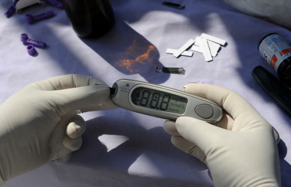 An Indian nurse checks readings on a glu