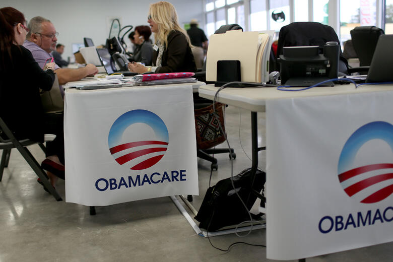 MIAMI, FL - FEBRUARY 05:  Aymara Marchante (L) and Wiktor Garcia sit with Maria Elena Santa Coloma, an insurance advisor with UniVista Insurance company, as they sign up for the Affordable Care Act, also known as Obamacare, before the February 15th deadli