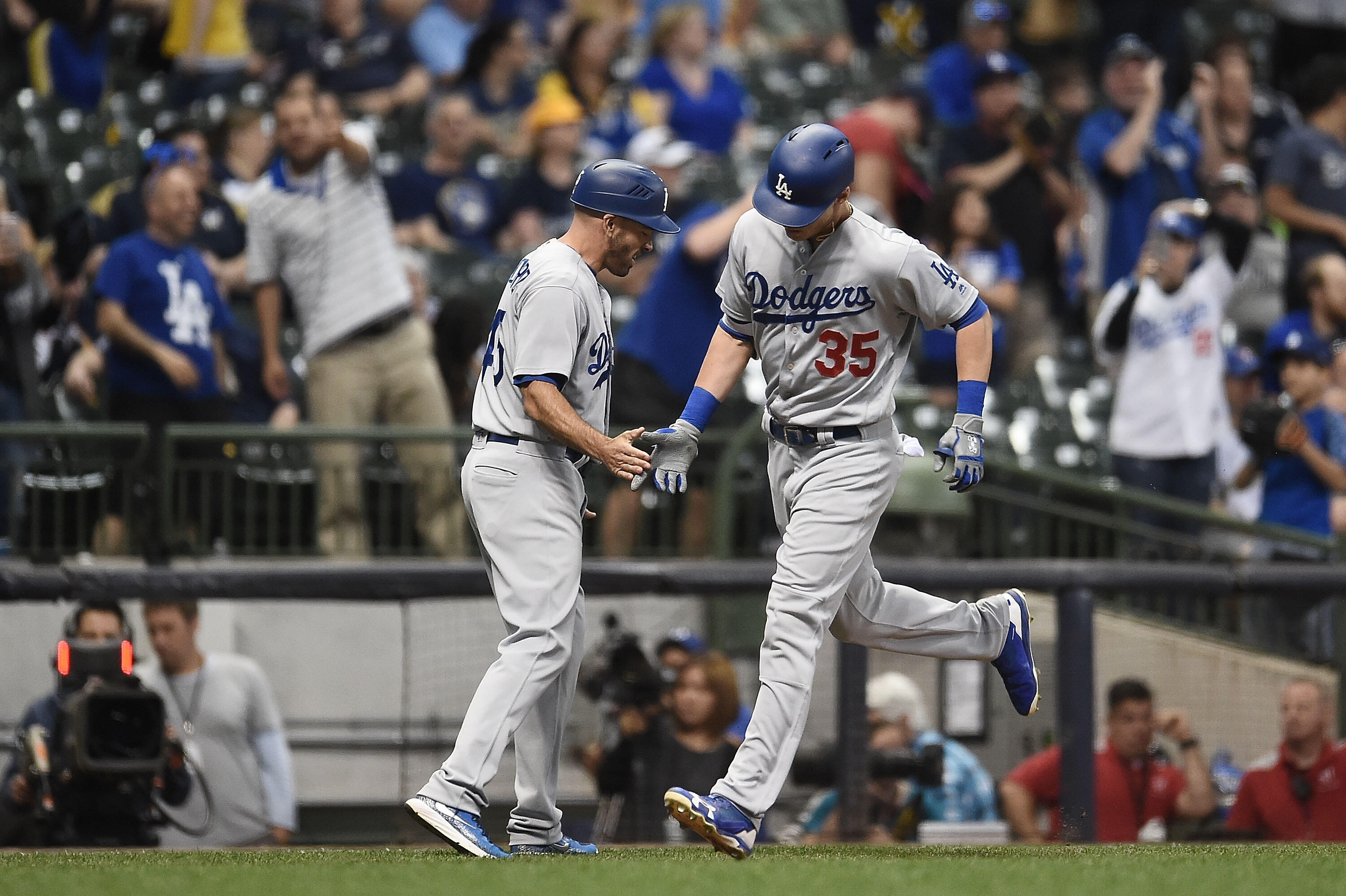 MILWAUKEE, WI - JUNE 02:  Cody Bellinger #35 of the Los Angeles Dodgers is congratulated by third base coach Chris Woodward #45 following a home run during the twelfth inning of a game against the Milwaukee Brewers at Miller Park on June 2, 2017 in Milwau