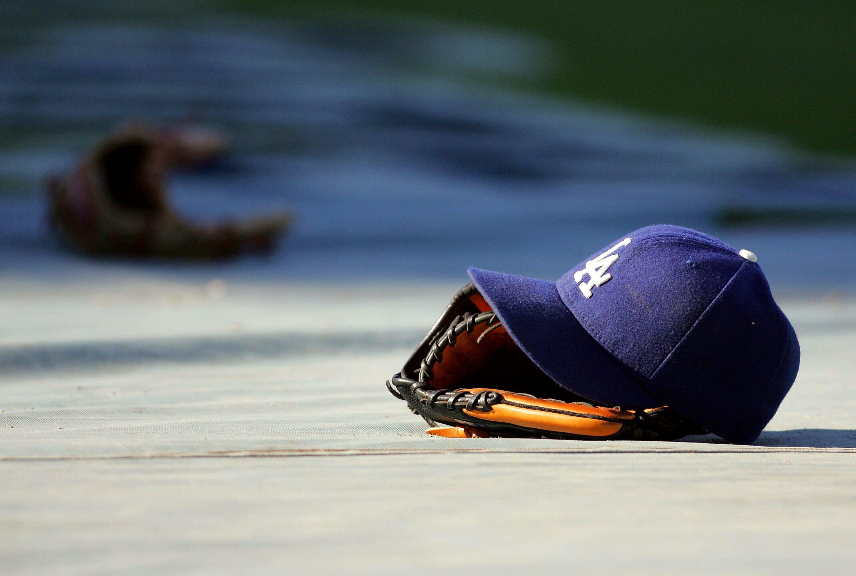 LOS ANGELES, CA - AUGUST 19:  A glove and a Los Angeles Dodgers cap lay on the tarp during batting practice prior to the MLB game against the Colorado Rockies at Dodger Stadium on August 19, 2008 in Los Angeles, California. The Rockies defeated the Dodger