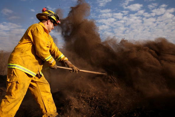 LA JOLLA, CA - OCTOBER 29:  Firefighter Brian Lieberman puts out flare-ups from the Poomacha fire October 29, 2007 in La Jolla, California. With improving weather conditions firefighters continued to make progress against wildfires in California. The fire