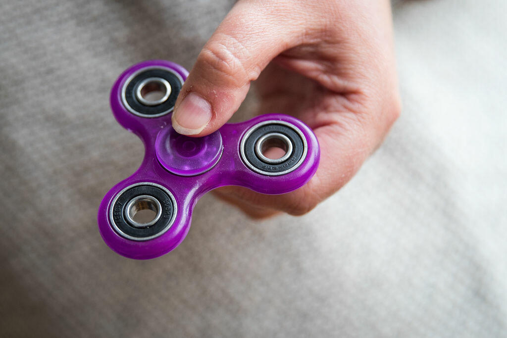 NEW YORK, NY - MAY 5: In this photo illustration, a woman holds a fidget spinner, May 5, 2017 in the Brooklyn borough of New York City. Fidget spinners have become the latest toy sensation and some schools have banned them because they've become a distraction. (Photo Illustration by Drew Angerer/Getty Images)
