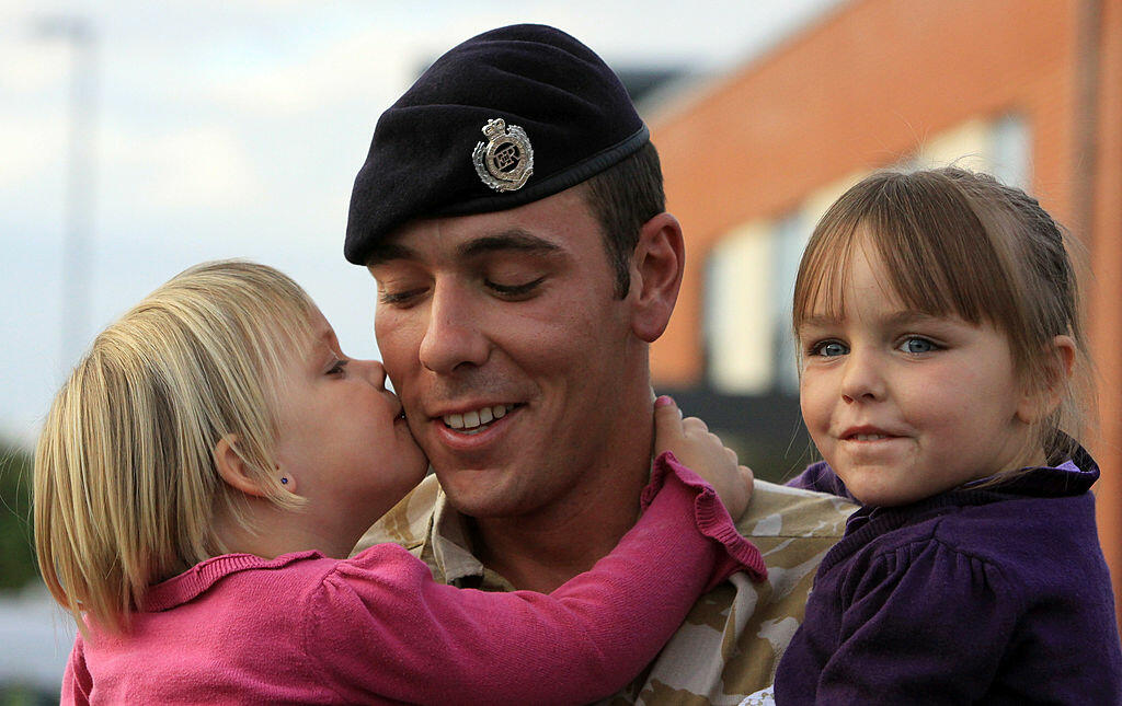 TIDWORTH, ENGLAND - SEPTEMBER 20:  Sapper Russell Kirkham from 33 Armoured Engineer Squadron is welcomed home by his daughters Kaitlyn, 3, (L) and Courtney, 4, (R) at Swinton Barracks, Perham Down, on September 20, 2009 in Tidworth, England. 33 Armoured E