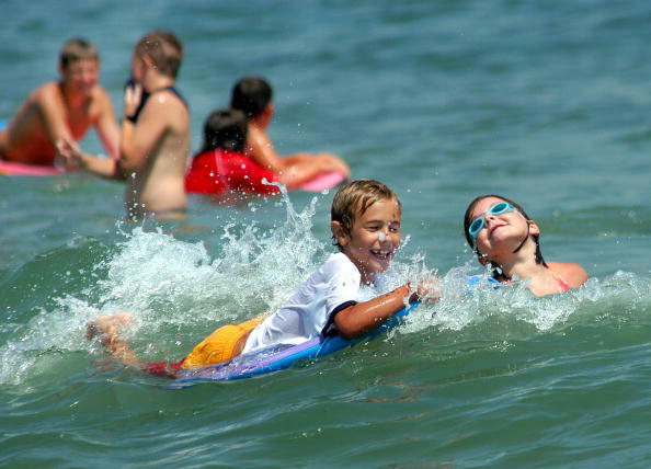 BRADLEY BEACH, NJ - AUGUST 15: Children play in the surf as they enjoy the cool waters of the Atlantic Ocean August 15, 2003 in Bradley Beach, New Jersey. New Jersey Governor James McGreevey urged New Yorkers to utilize the New Jersey beaches after the Ne