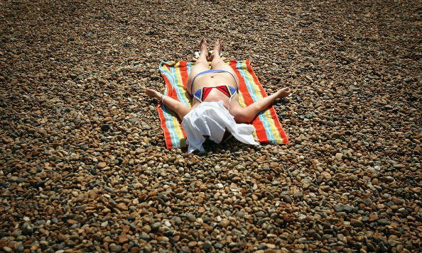 BRIGHTON, UNITED KINGDOM - JUNE 19:  A woman sleeps in the sun on Brighton Beach, June 19, 2005 in Brighton, England.  Temperatures are likely to soar to 33C (91F) in London with similar highs in the south east.  (Photo by Bruno Vincent/Getty Images)