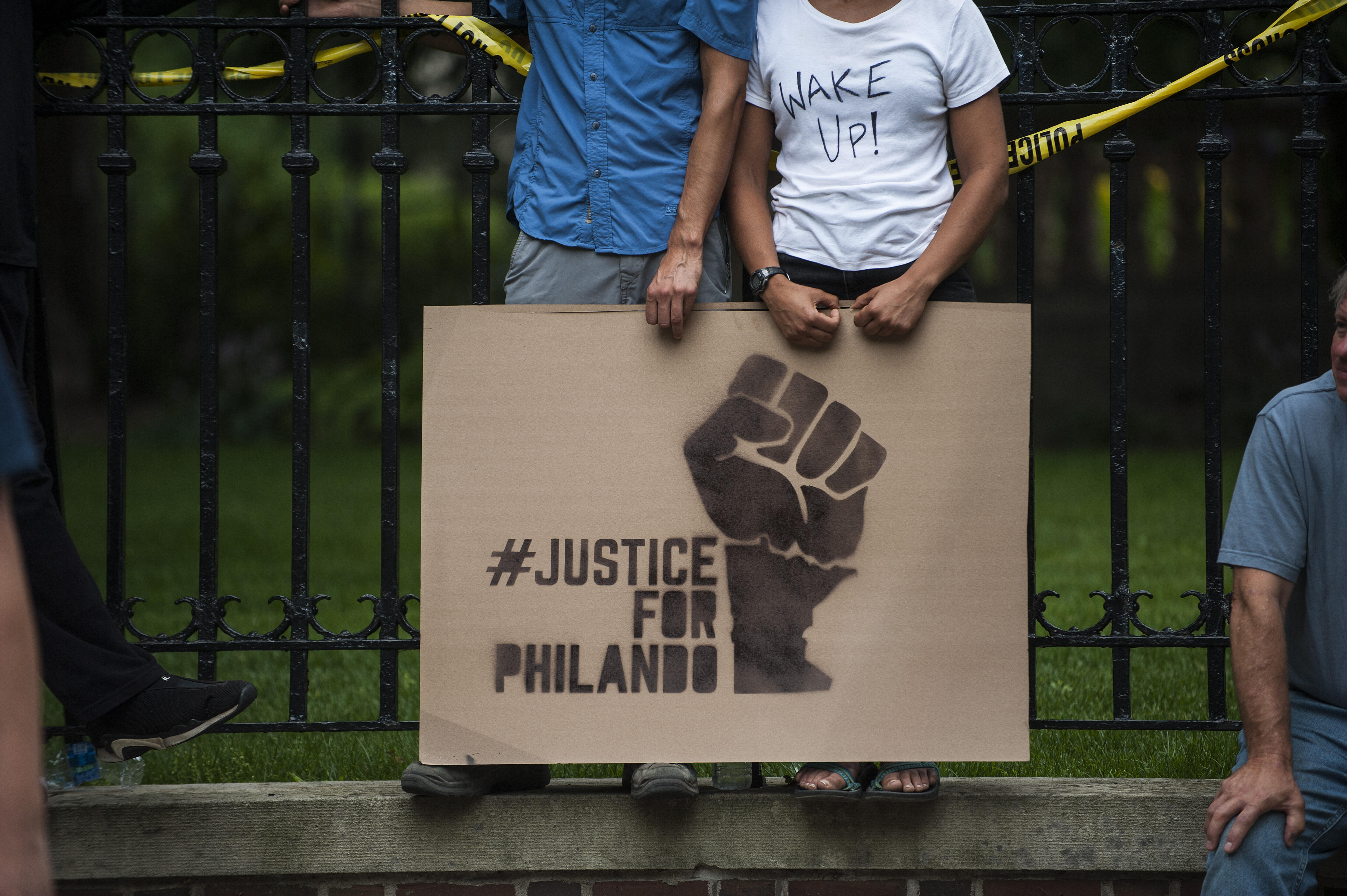 ST. PAUL, MN - JULY 07: A couple hold a sign protesting the killing of Philando Castile outside the Governor's Mansion on July 7, 2016 in St. Paul, Minnesota. Castile was shot and killed the previous night by a police officer in Falcon Heights, MN. (Photo