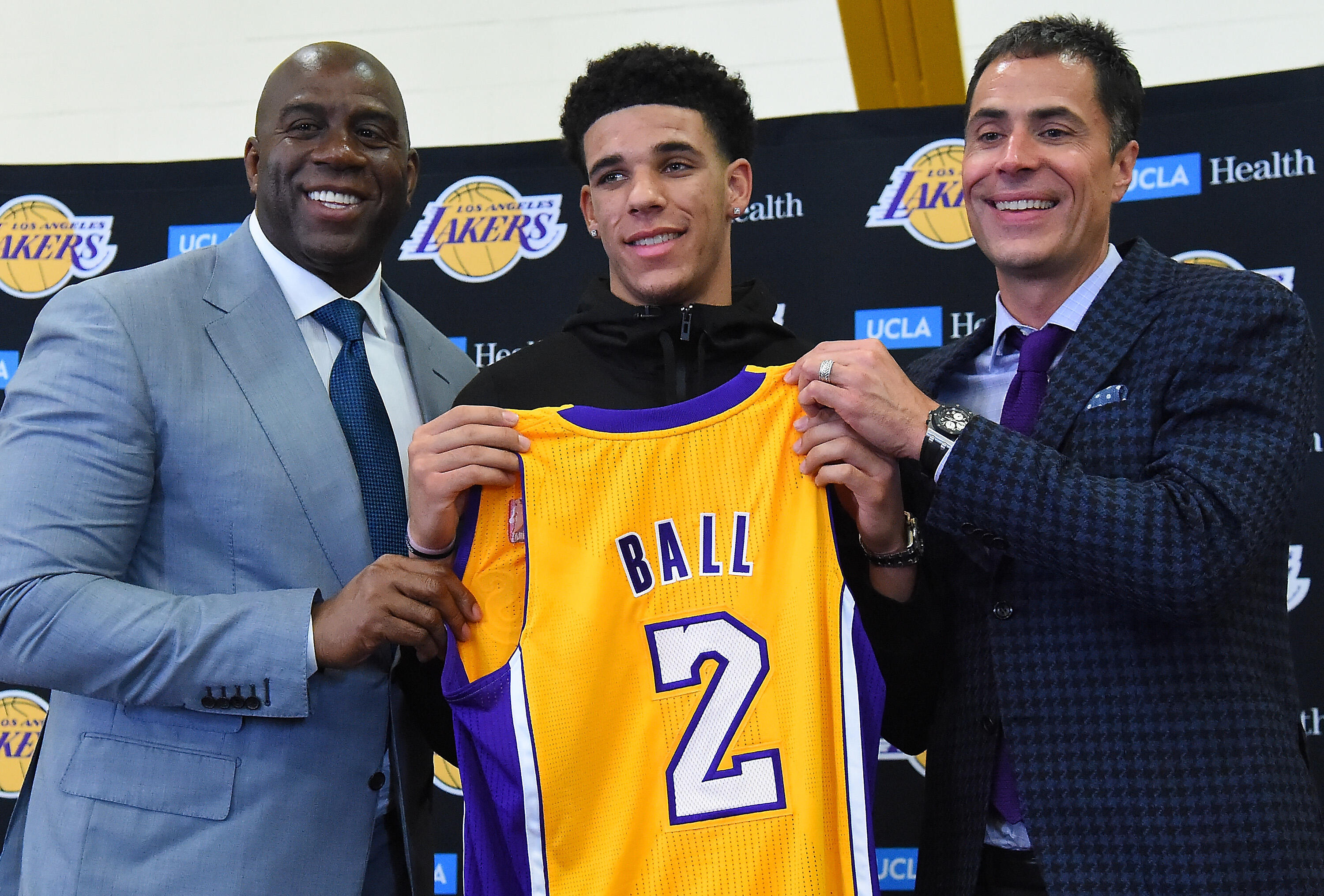 LOS ANGELES, CA - JUNE 23:  Magic Johnson, president of basketball operations of the Los Angeles Lakers along with general manager Rob Pelinka present Lonzo Ball his jersey during a press conference on June 23, 2017 at the team training faculity in Los An