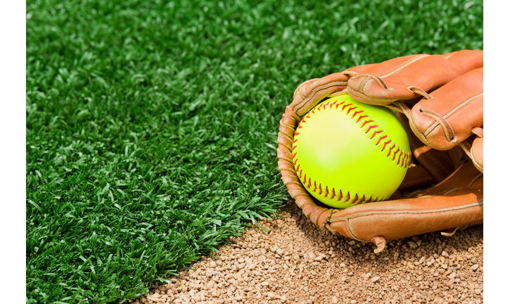 New Fast Pitch Softball in glove sitting on infield