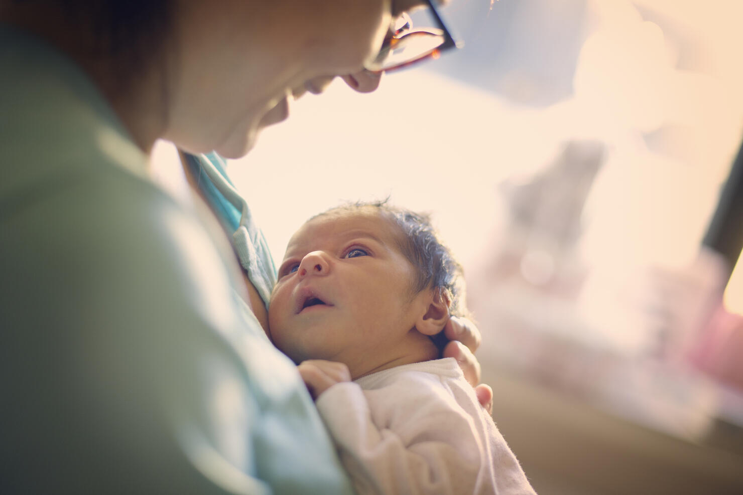 Mom smiling at newborn at hospital