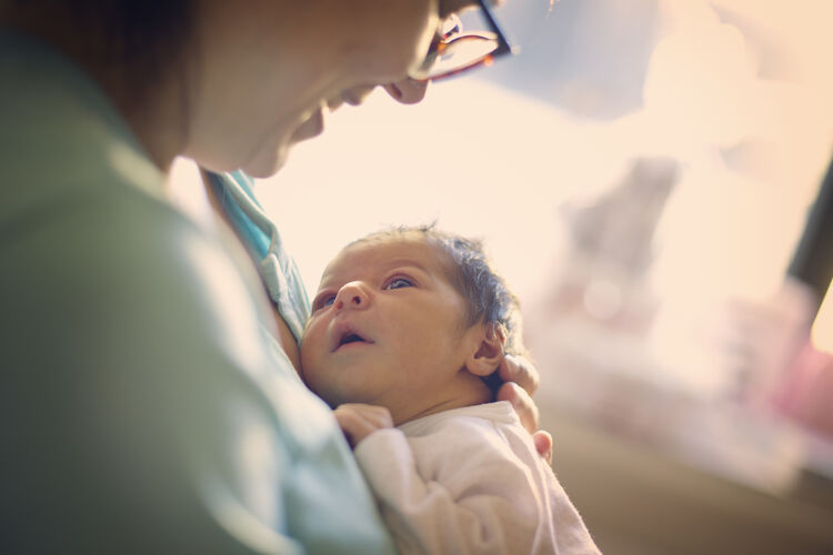 Mom smiling at newborn at hospital