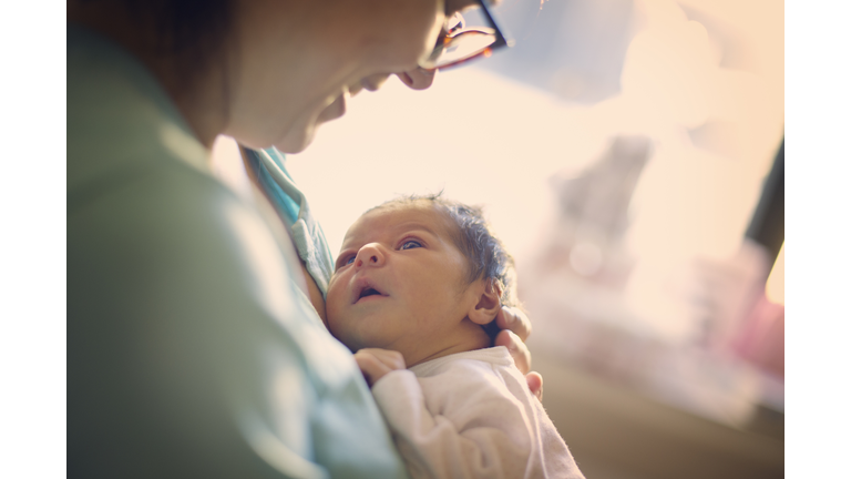 Mom smiling at newborn at hospital