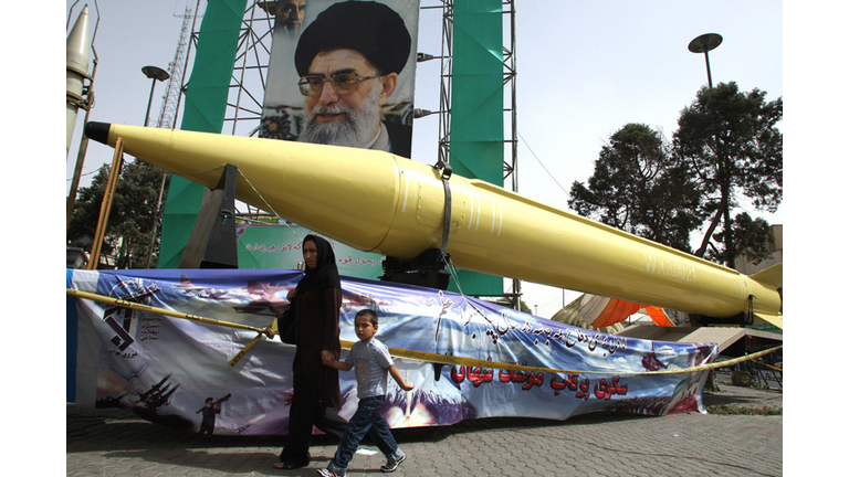 An Iranian woman and her son walk past S