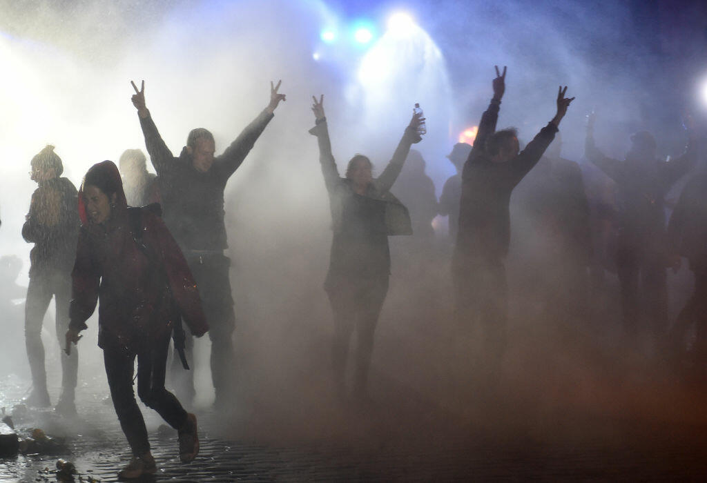 Demonstrators are doused with water cannon by police during riots on July 8, 2017 in Hamburg, northern Germany, after the leaders of the world's top economies gathered for a G20 summit.  German police and protestors had clashed already the day before at an anti-G20 march, with police using water cannon and tear gas to clear a hardcore of masked anti-capitalist demonstrators.  / AFP PHOTO / Christof STACHE        (Photo credit should read CHRISTOF STACHE/AFP/Getty Images)