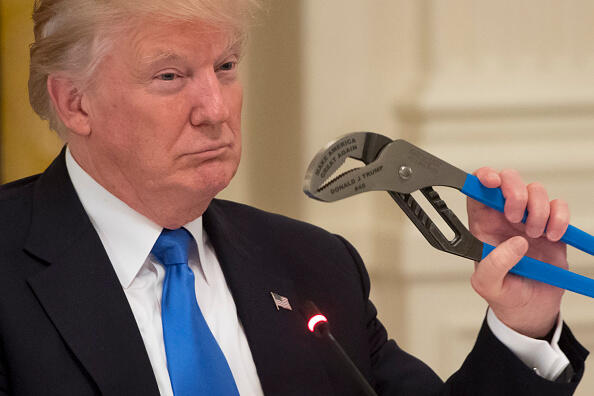 US President Donald Trump holds up a pair of pliers as he speaks during a Made in America event with US manufacturers in the East Room of the White House in Washington, DC, July 19, 2017. / AFP PHOTO / SAUL LOEB (Photo credit should read SAUL LOEB/AFP/Getty Images)