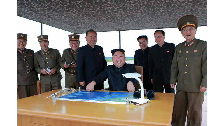 North Korean leader Kim Jong-Un (C) watching the launch of an intermediate-range strategic ballistic rocket Hwasong-12 