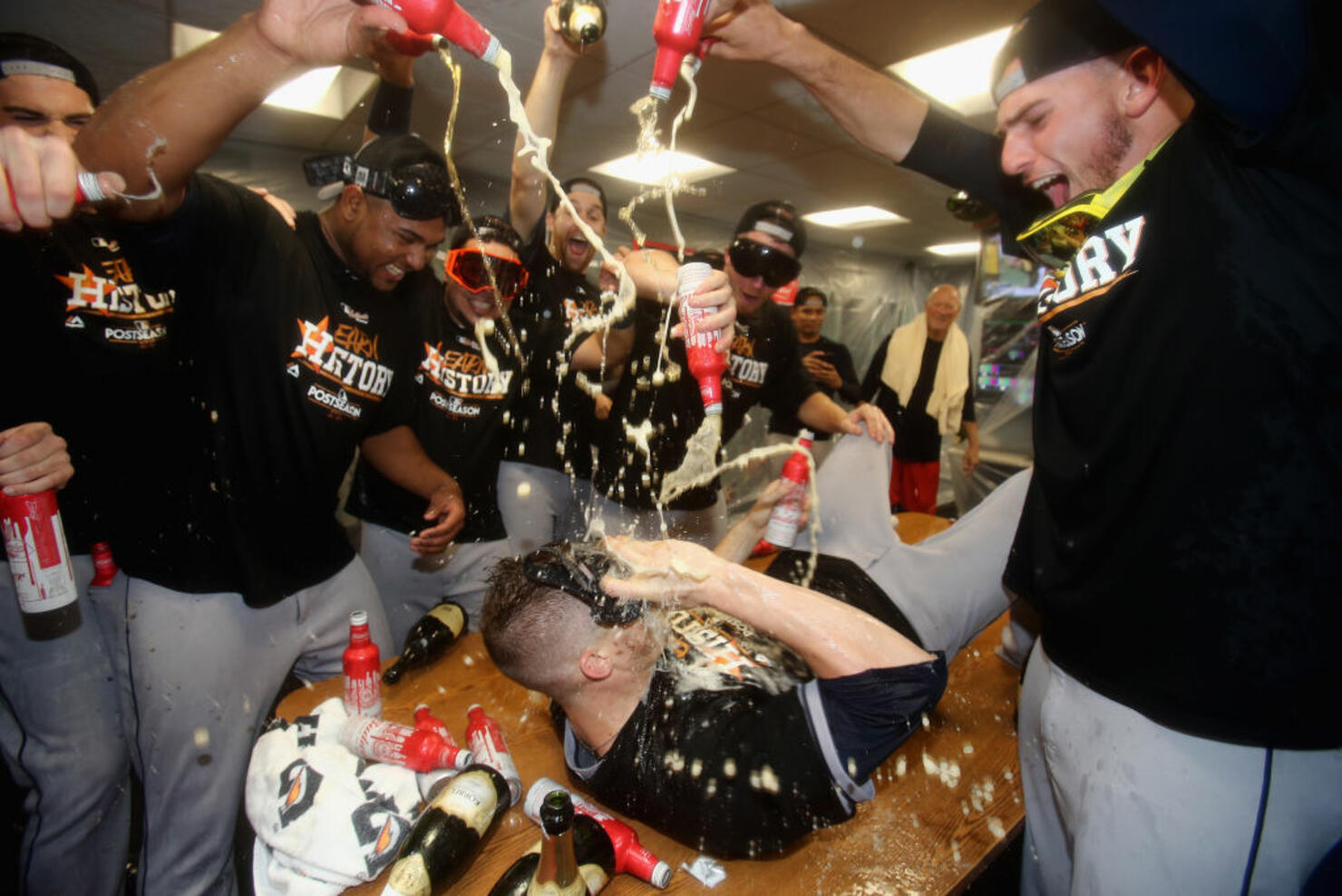Ken Giles #53 of the Houston Astros (on table) celebrates with teammates in the clubhouse