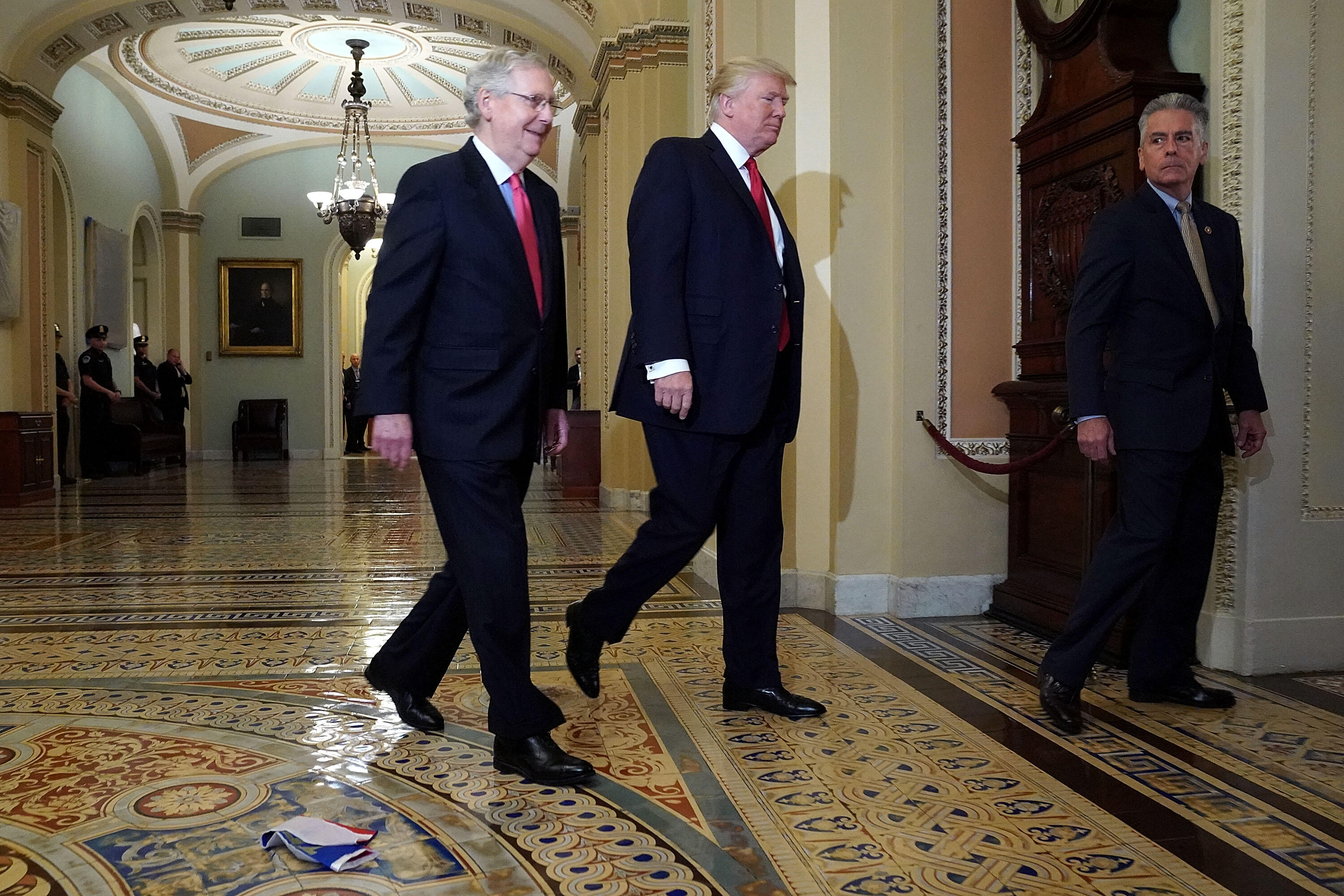 WASHINGTON, DC - OCTOBER 24: Senate Majority Leader Mitch McConnell (R-KY) (L) and U.S. President Donald Trump arrive for the Republican Senate Policy Luncheon and walk past a Russian flag on the floor that was thrown at the U.S. Capitol October 24, 2017 in Washington, DC. Trump joined the senators to talk about upcoming legislation, including the proposed GOP tax cuts and reform. (Photo by Chip Somodevilla/Getty Images)