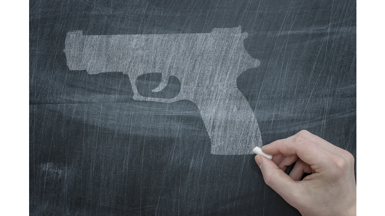 Gun on Chalkboard Getty Images